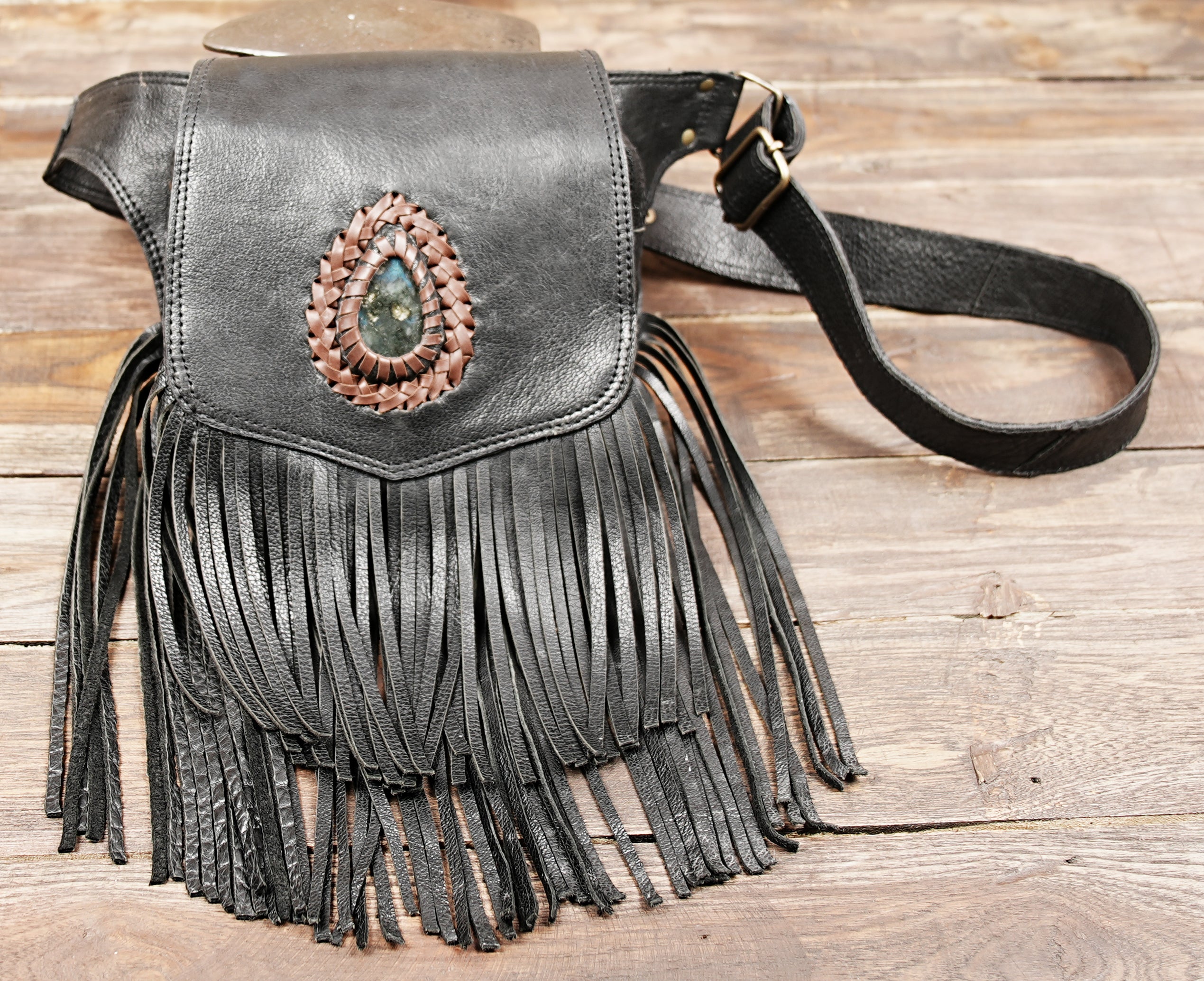 side angle view of fringe holster bag with buckle strap detail