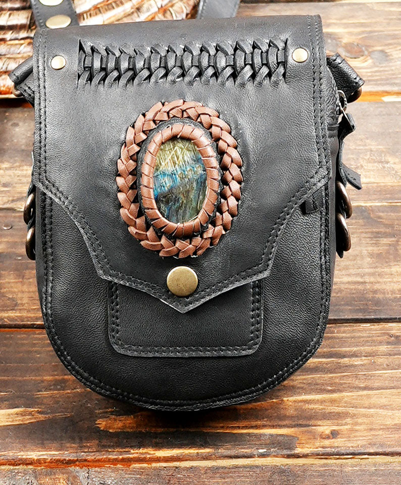 Close-up of blue gemstone accent on handmade leather holster bag
