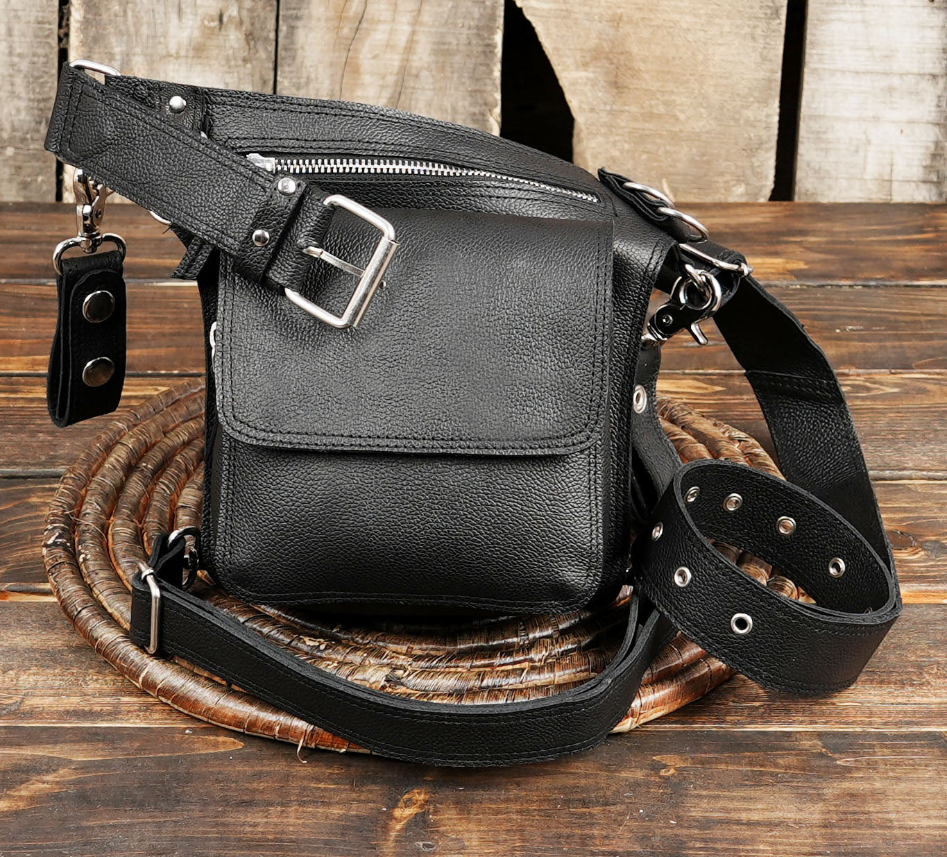 Stylish black hip bag with front flap pocket and detachable straps.