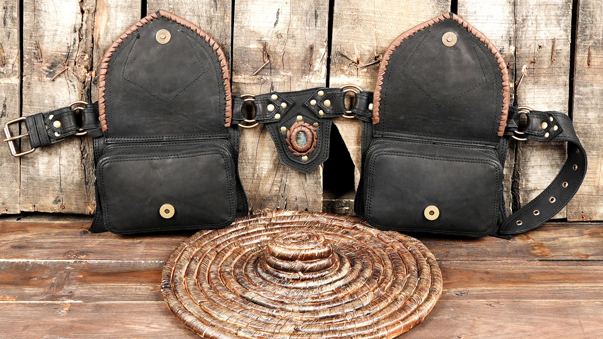 Black leather hip bag with gemstone accent and adjustable belt strap