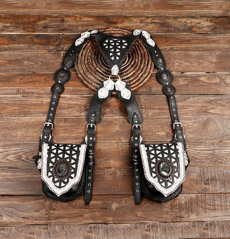 Handmade black leather holster bag with gemstone detail on wood background