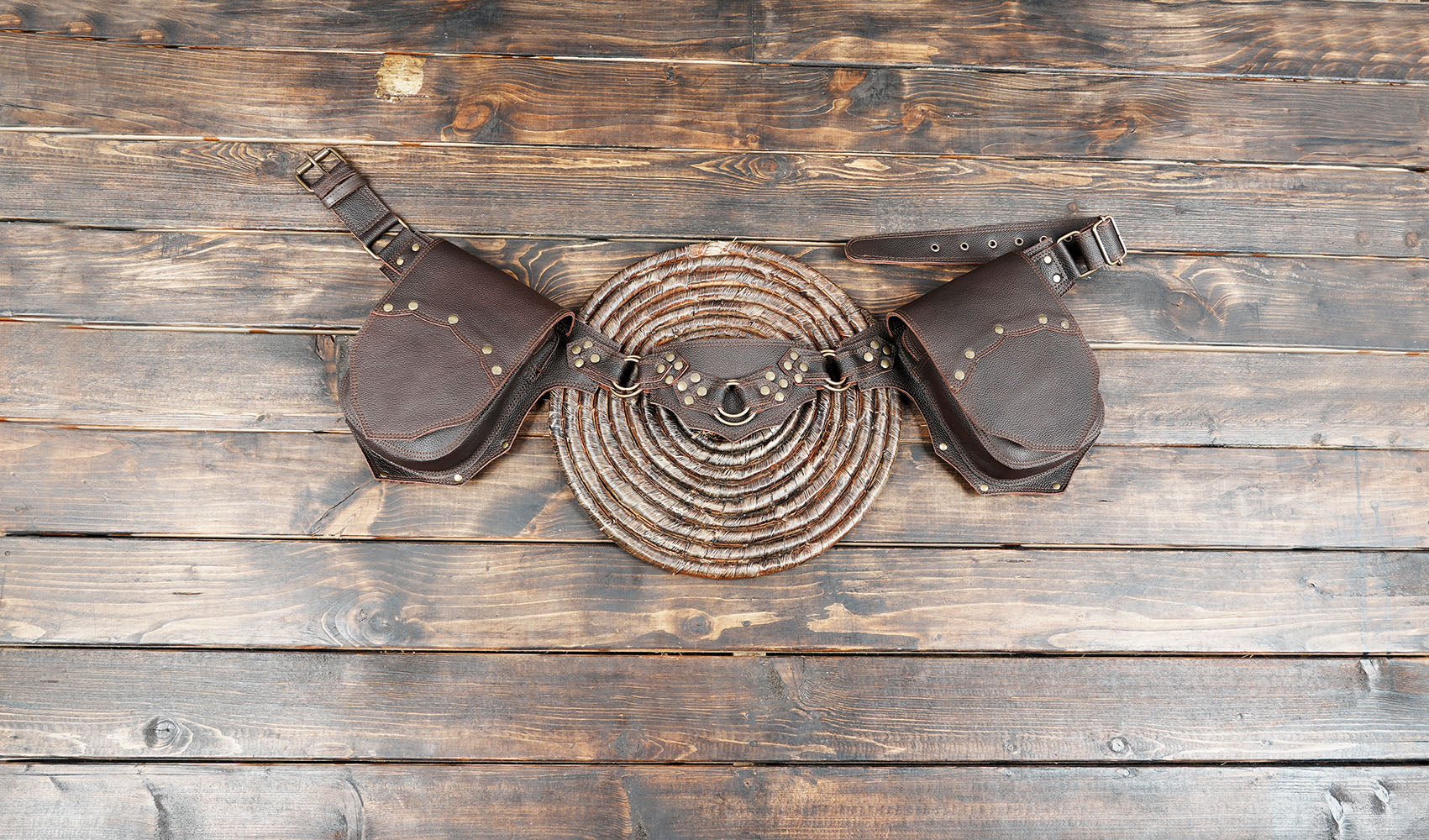 Handmade brown leather steampunk utility belt bag on wooden table