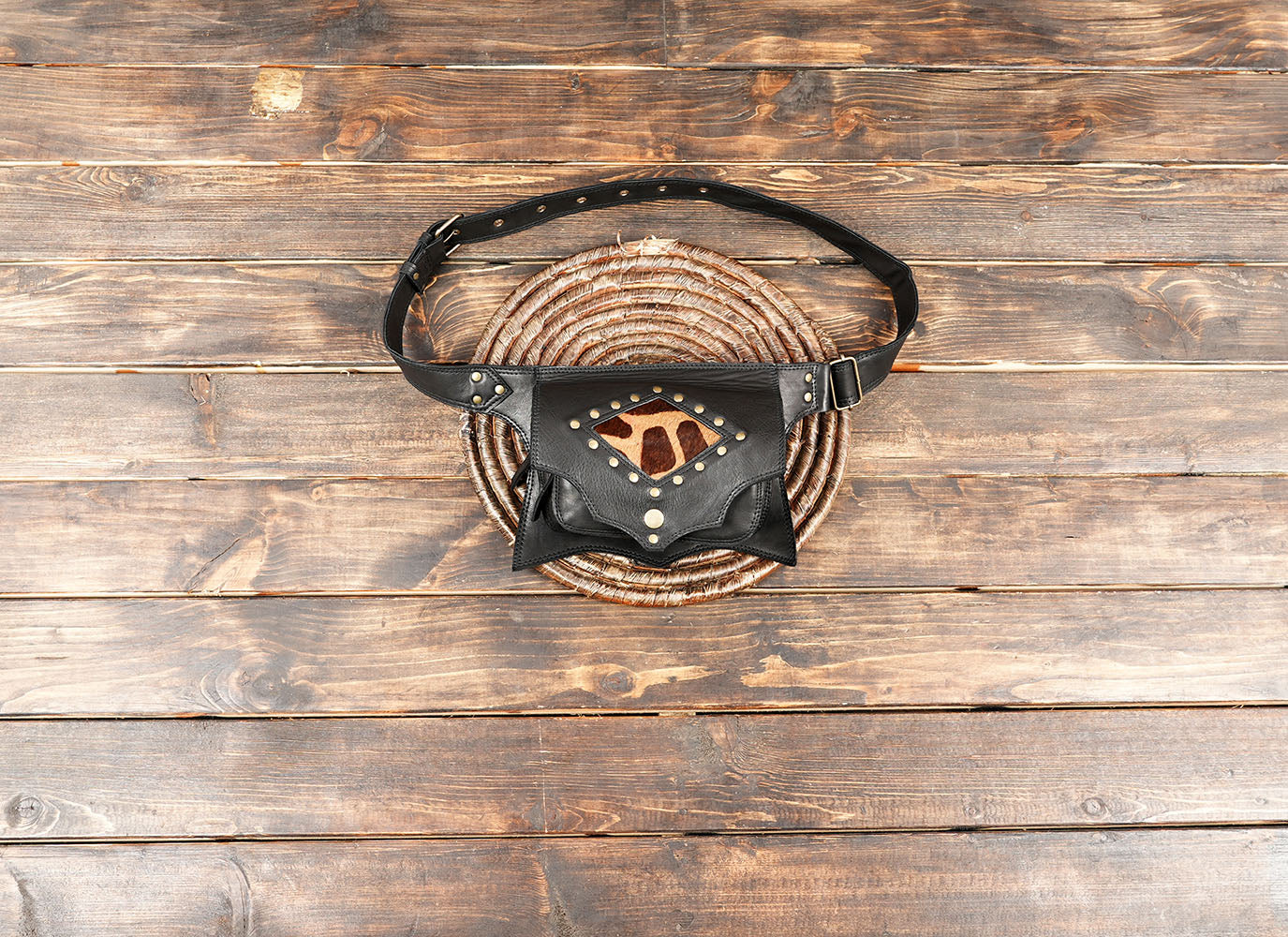 Close-up of black leather fanny pack with animal print cowhide insert