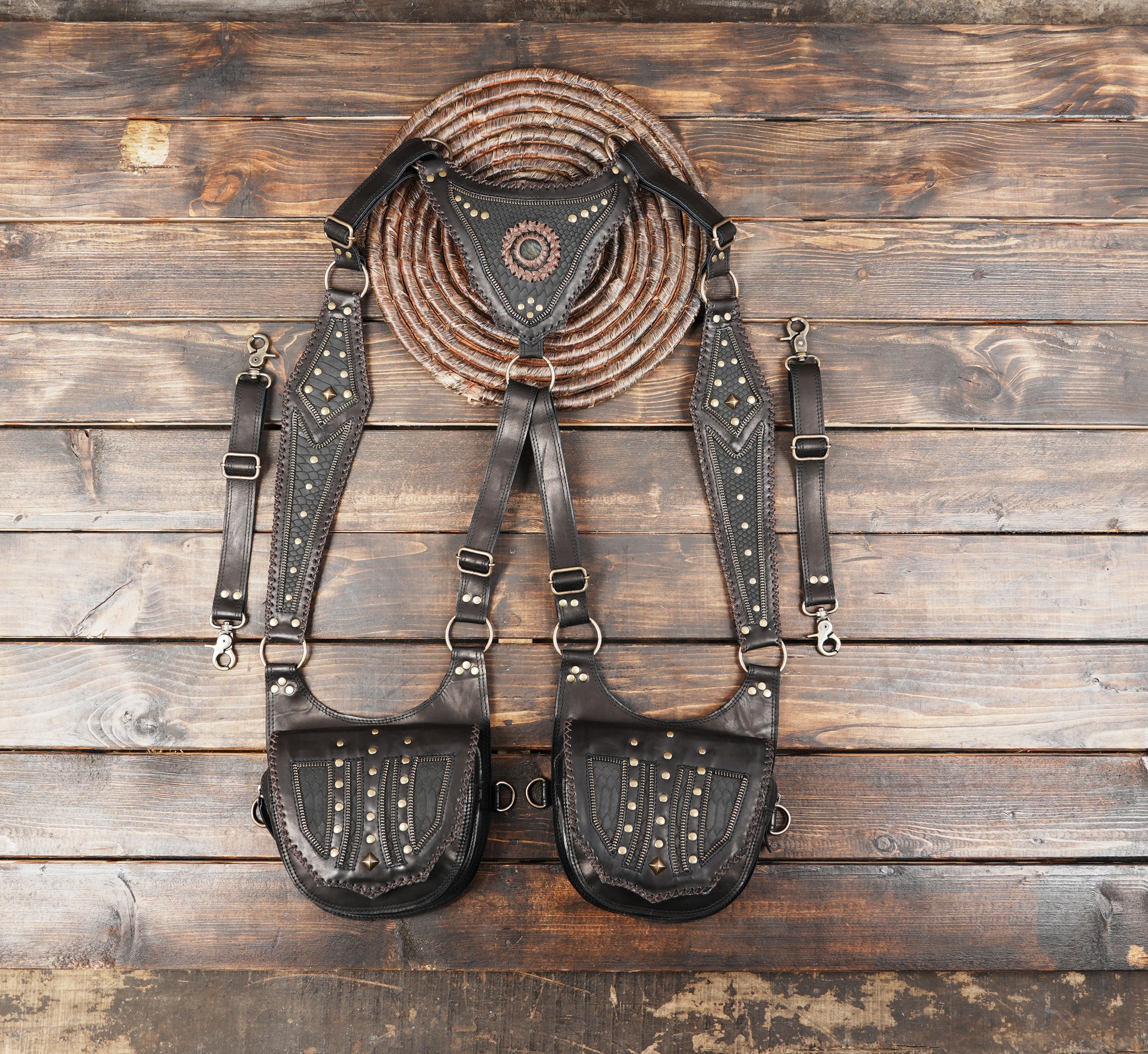 black leather harness holster bag with twin pouches and decorative medallion