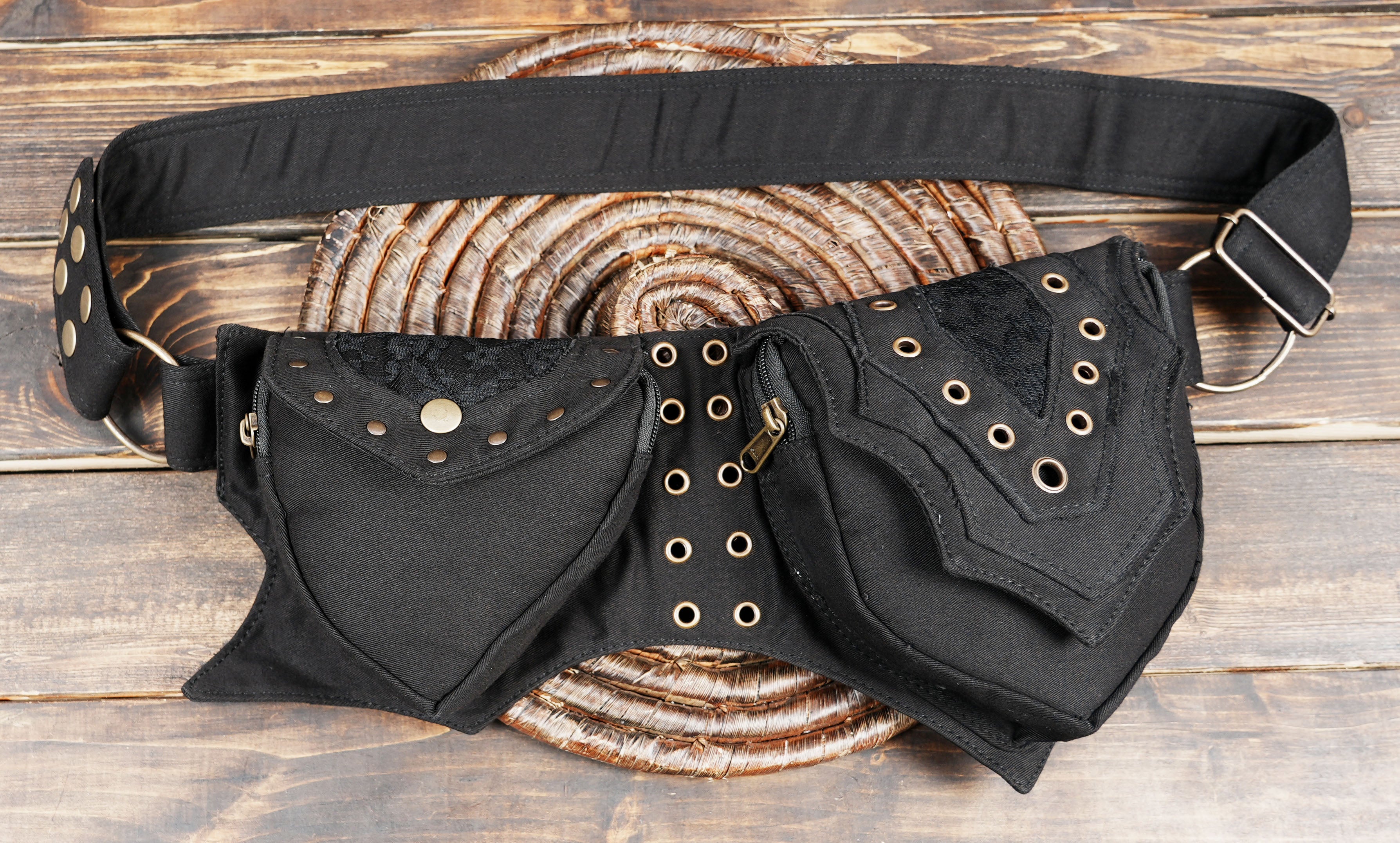 Close-up of black festival belt bag with bronze studs and lace texture
