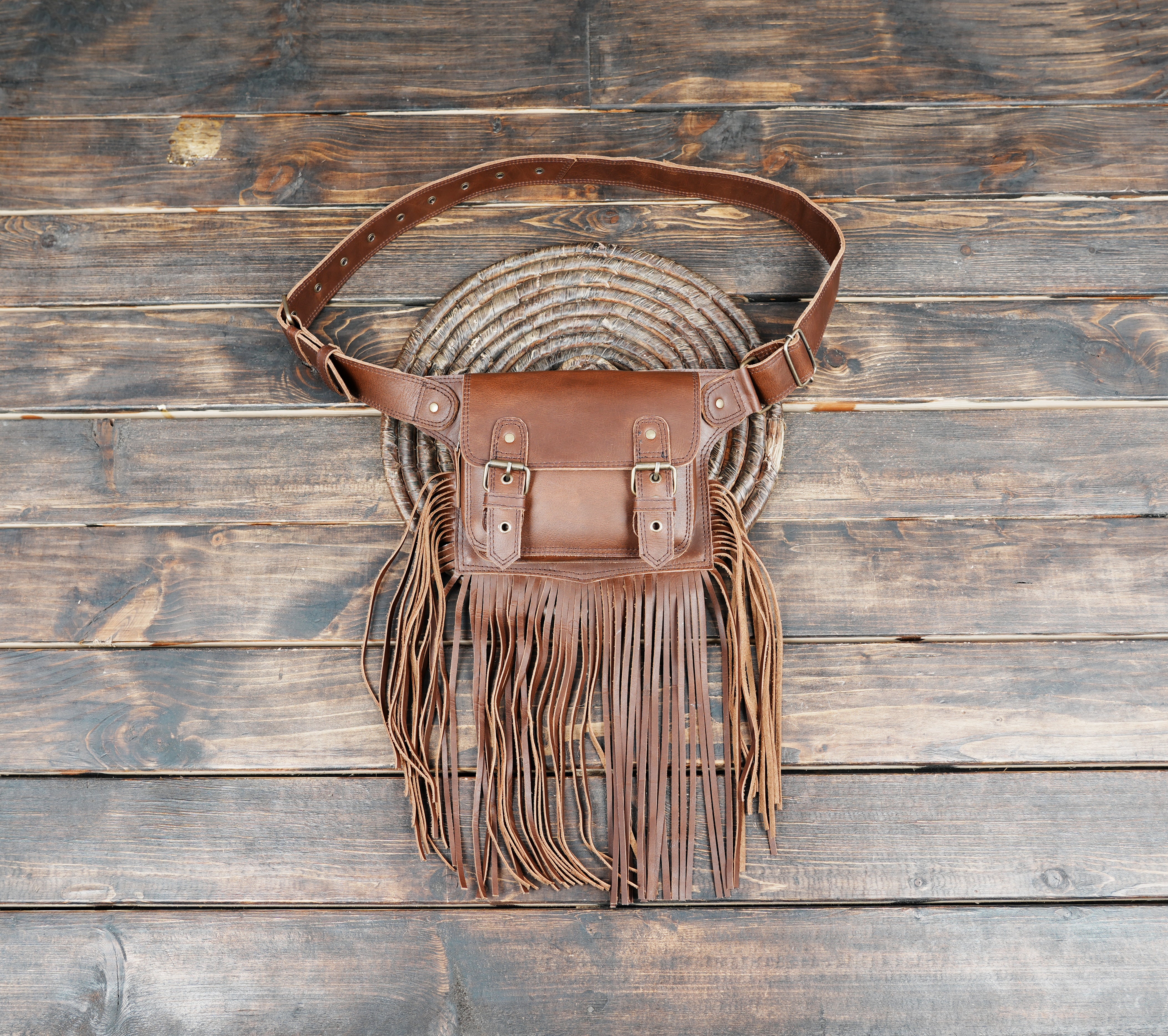 Brown leather waist belt bag with long fringe and buckle closure