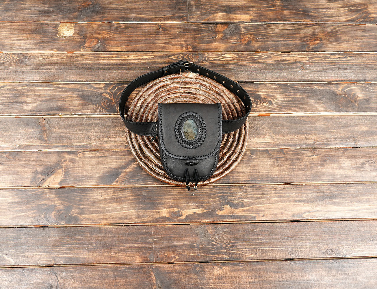 Handcrafted black leather belt bag with natural stone accent and braided stitching