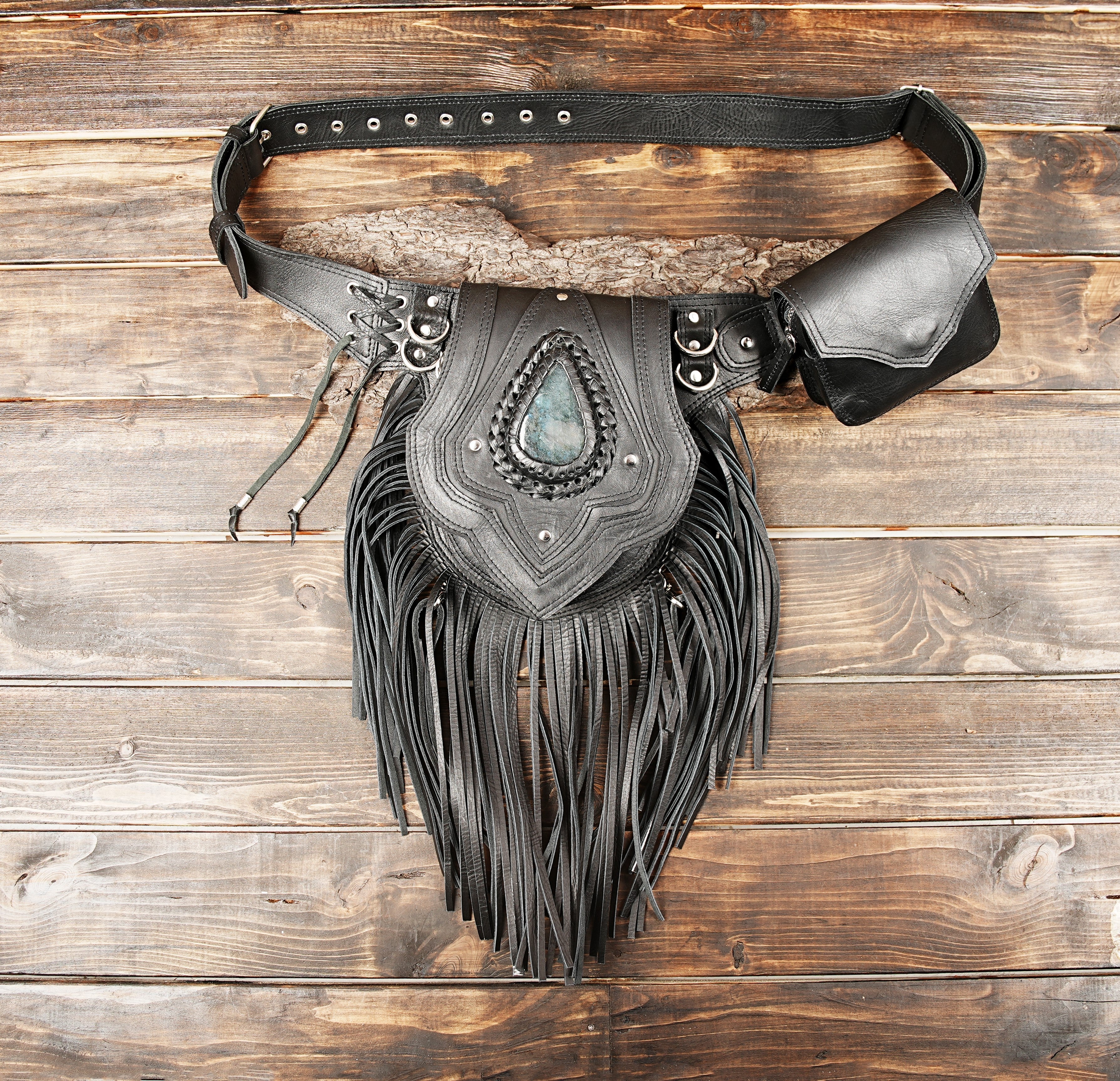 Handcrafted leather waist bag with detailed stitching and stone accent.