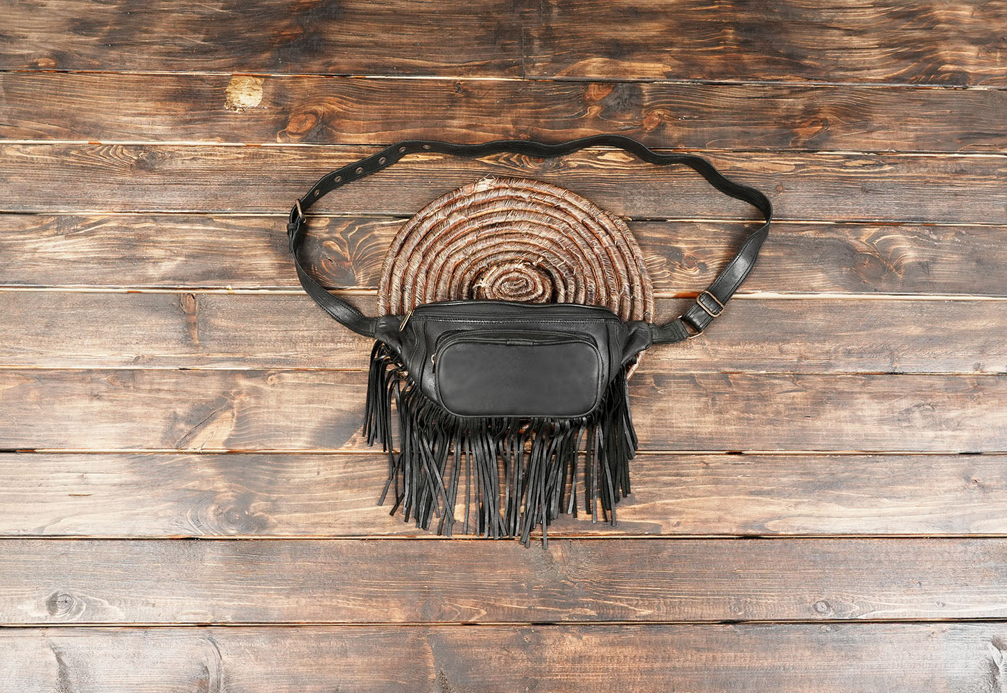 Black leather waist bag with fringe design and adjustable strap