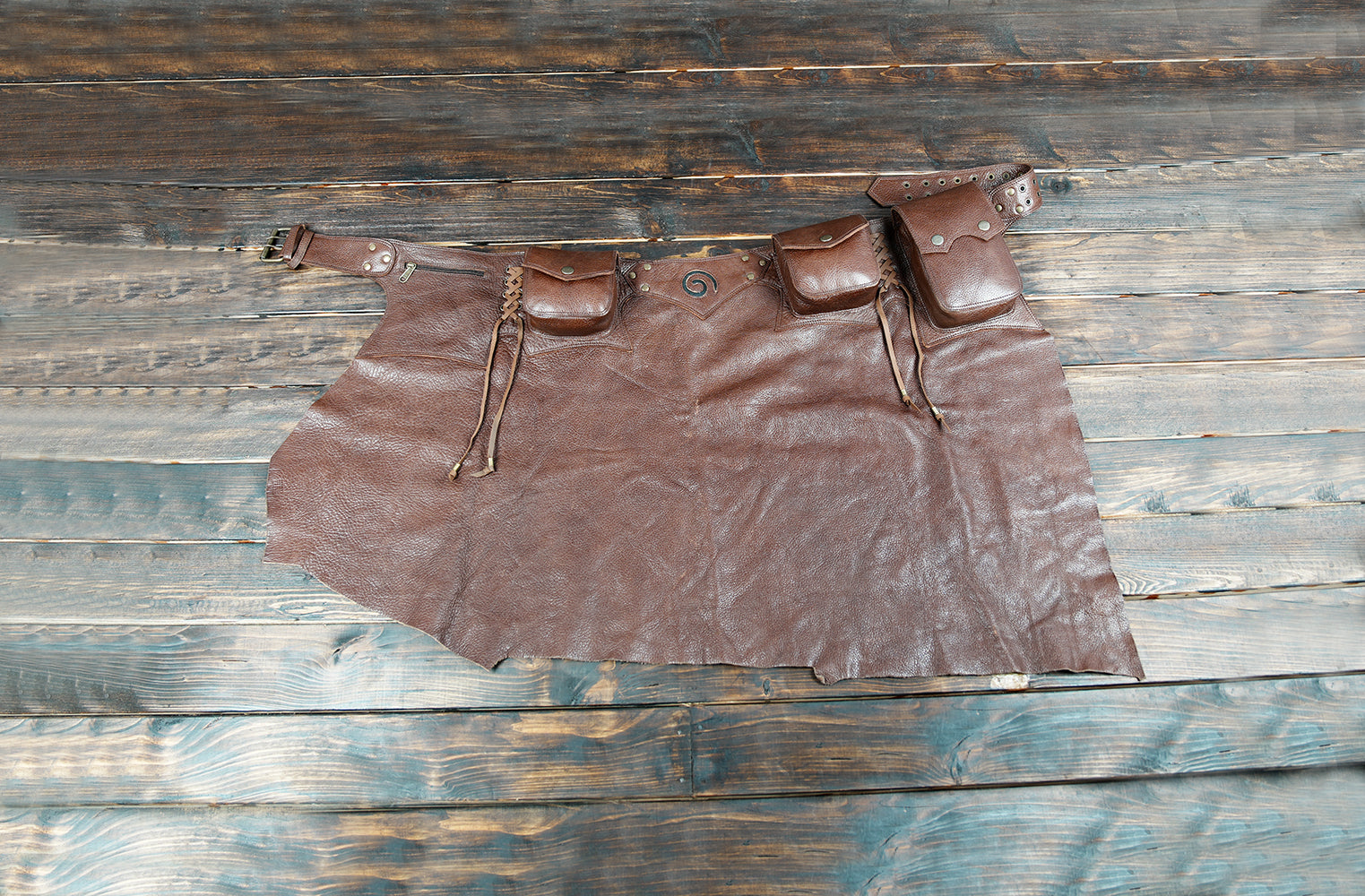 Handmade brown leather skirt with utility belt and attached pouches for festival wear.