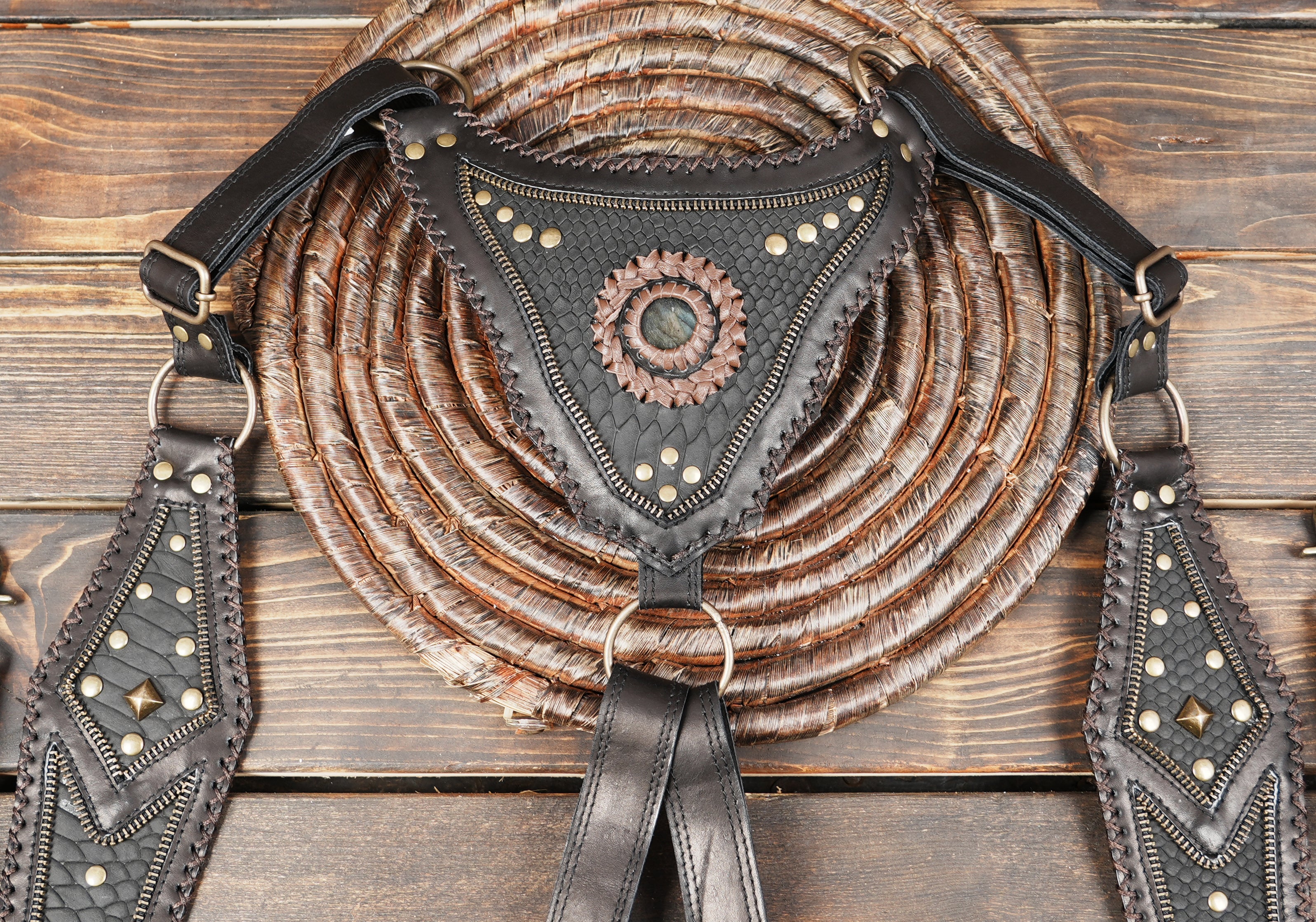 dual-pouch leather harness bag laid flat to show front and back