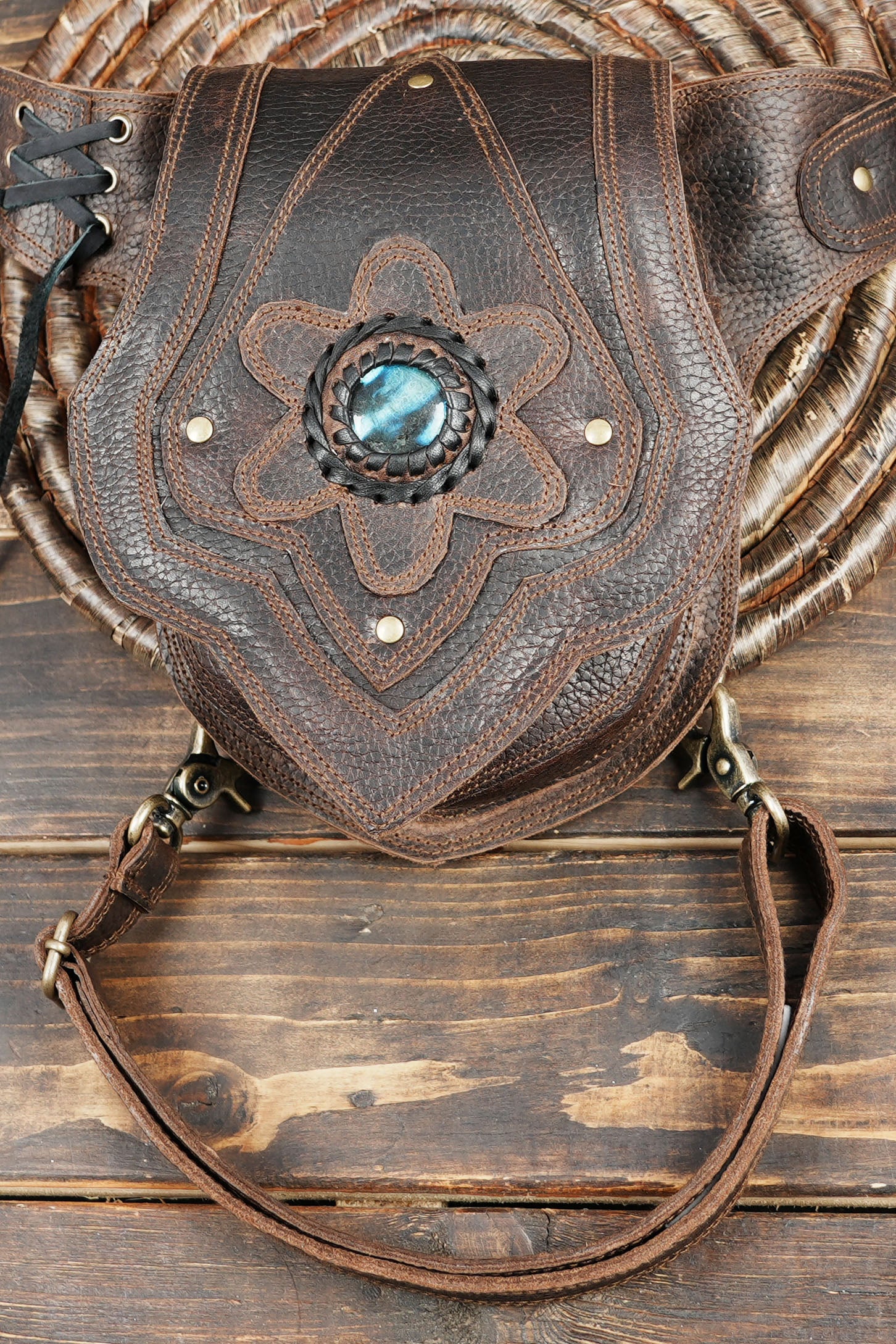 Artisan leather waist bag with embossed patterns and gemstone centerpiece