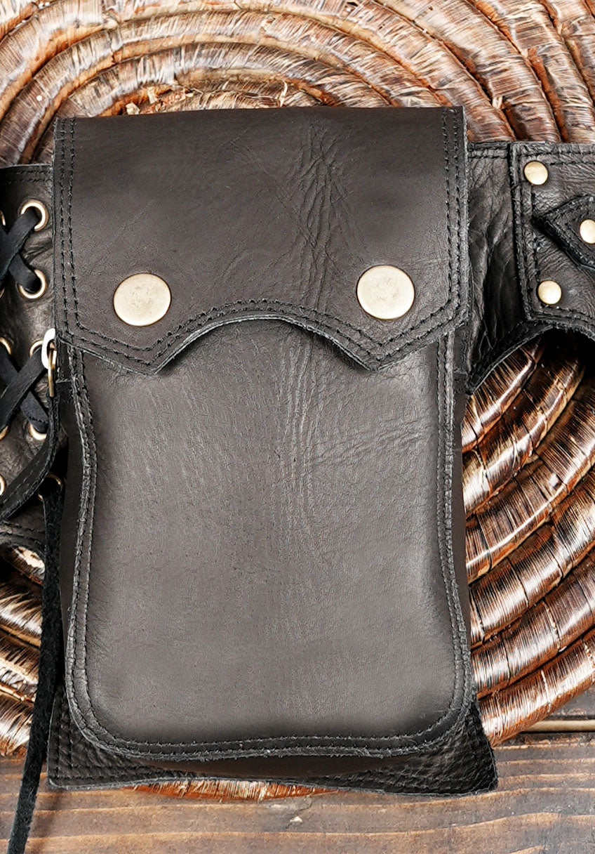 Boho Western-inspired utility belt bag on rustic wooden surface