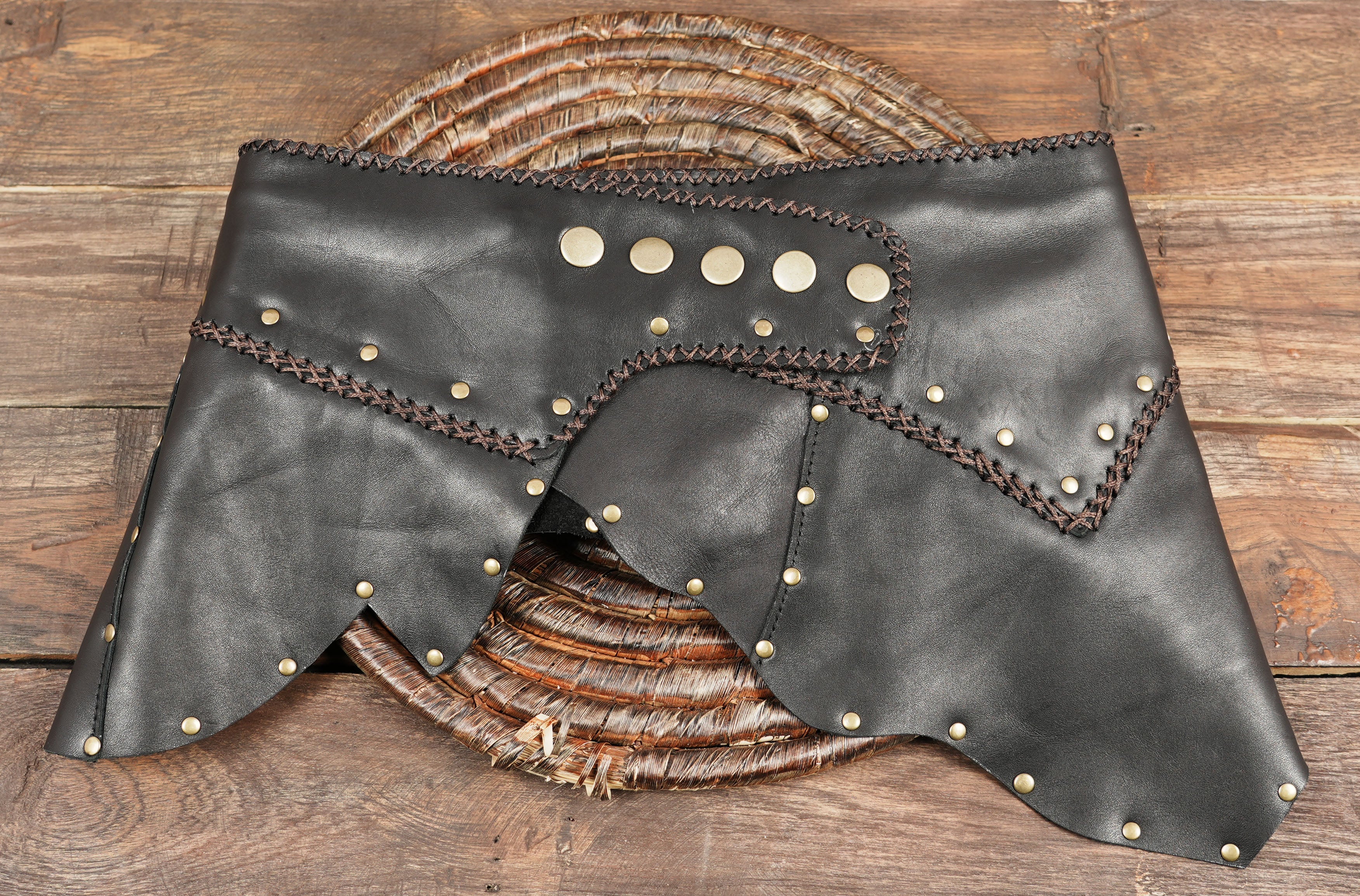 “Artisan leather skirt with studded details and rustic stitching, boho tribal cosplay outfit.”
