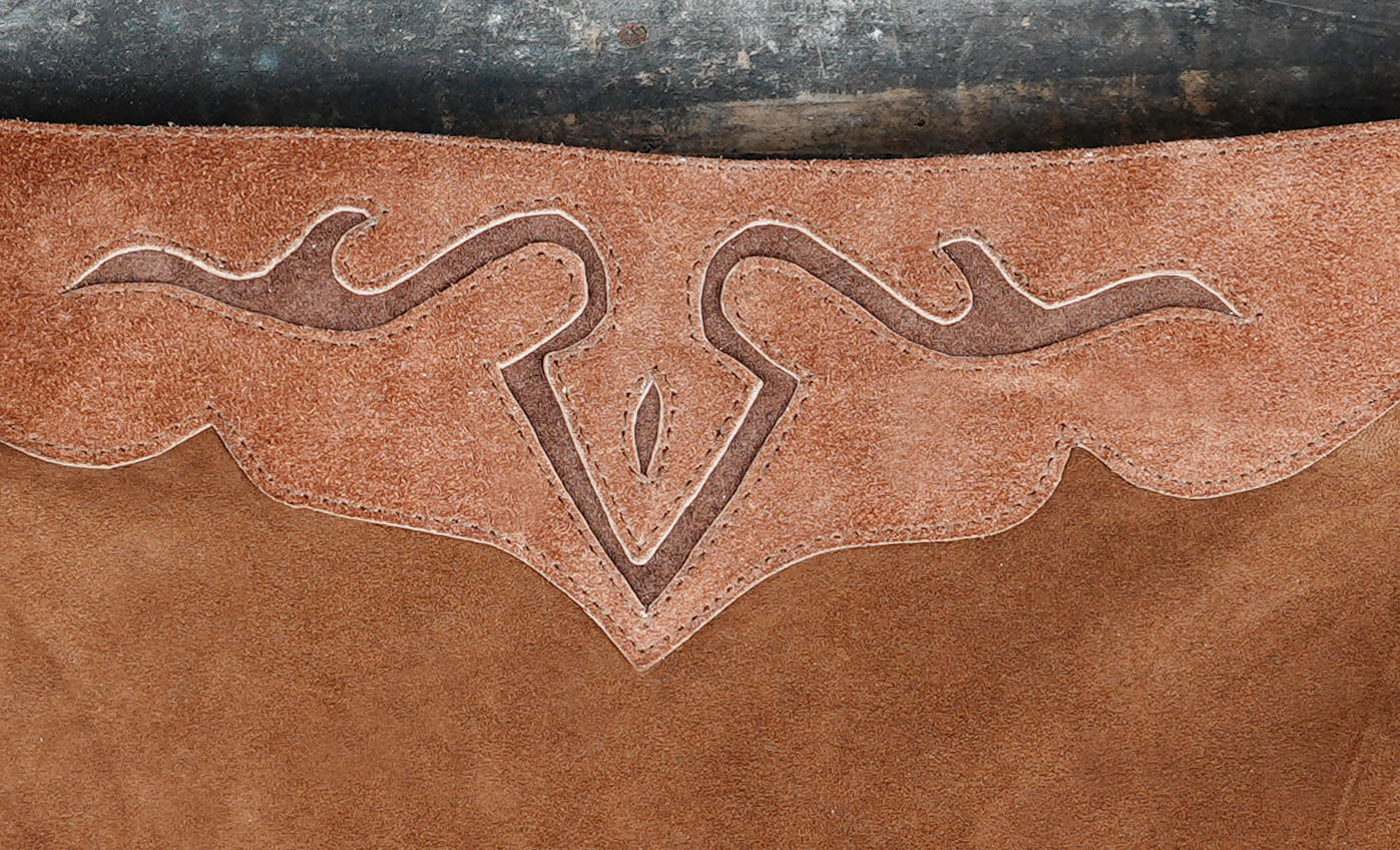 Handcrafted leather skirt with rustic design laid on wooden floor