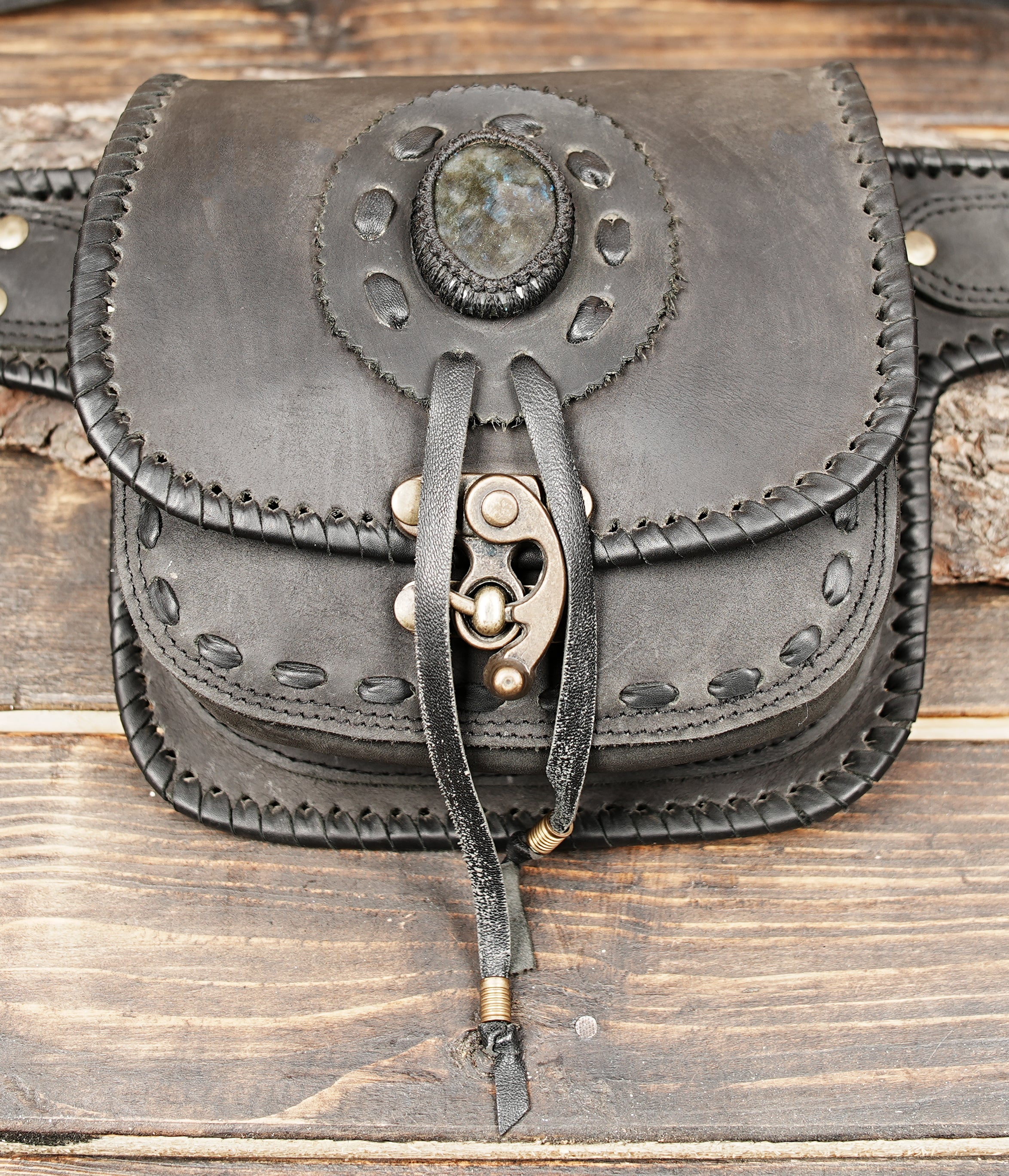 Black leather waist bag front view with gemstone