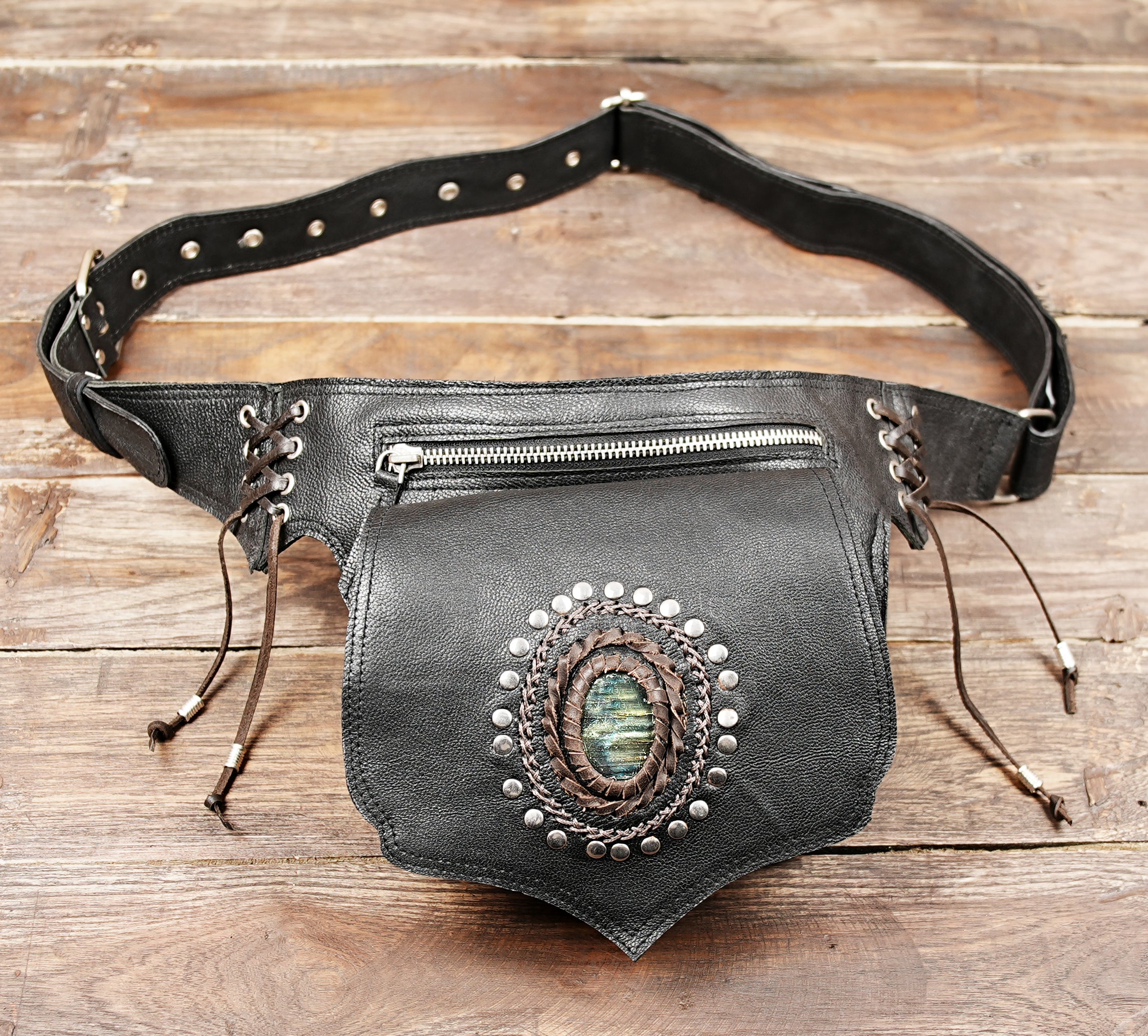 Unisex black leather belt bag with zipper pocket and gemstone centerpiece.
