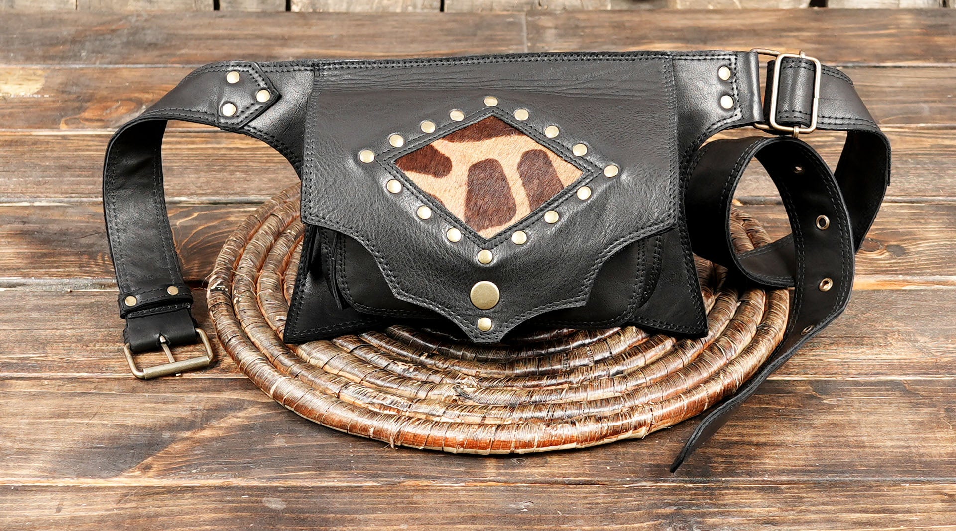 Cowhide and leather fanny pack for men and women on wooden background