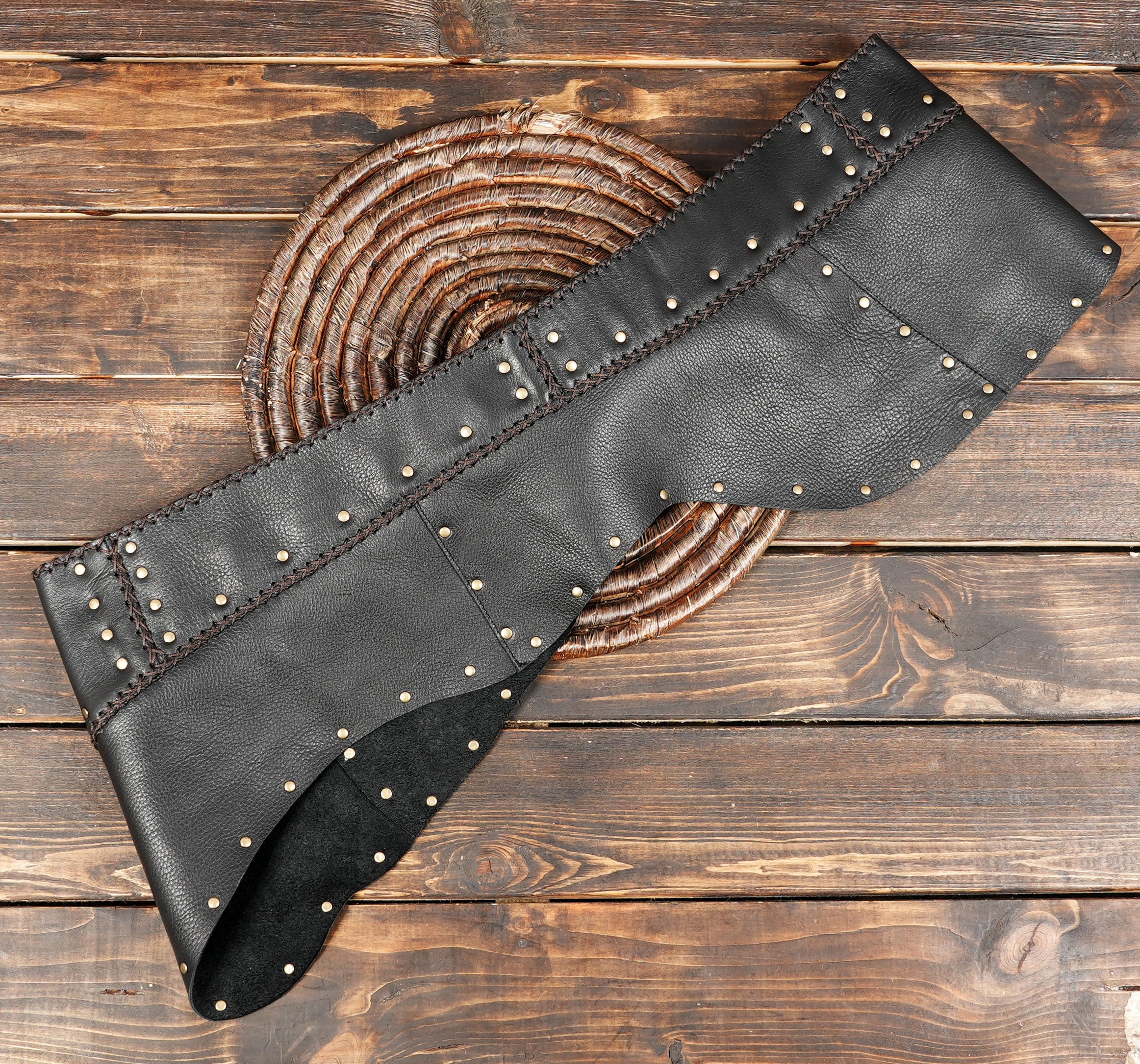 Western-style leather skirt with studs displayed on wood surface