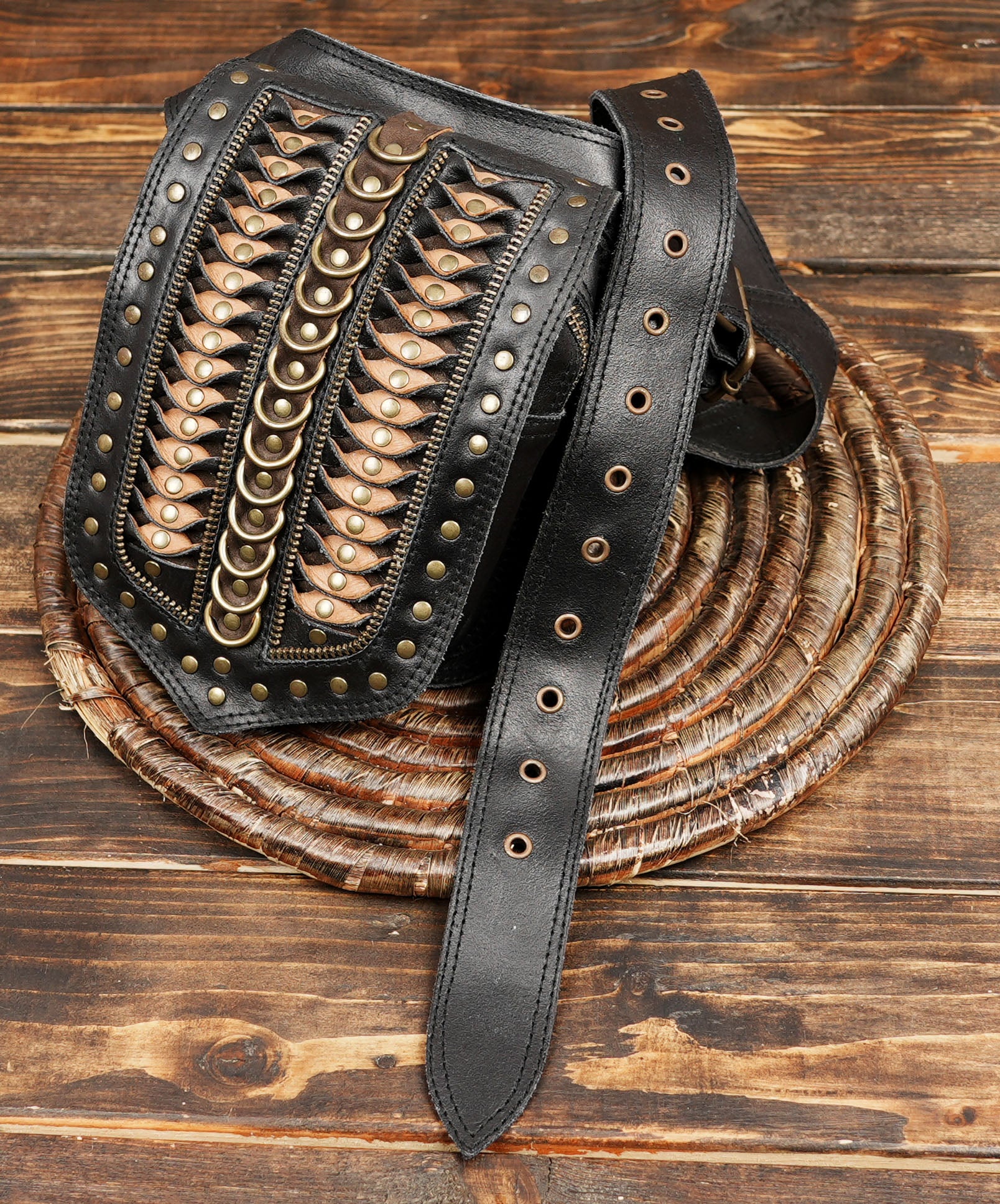 Women’s leather hip pouch with rivet details worn over patterned leggings