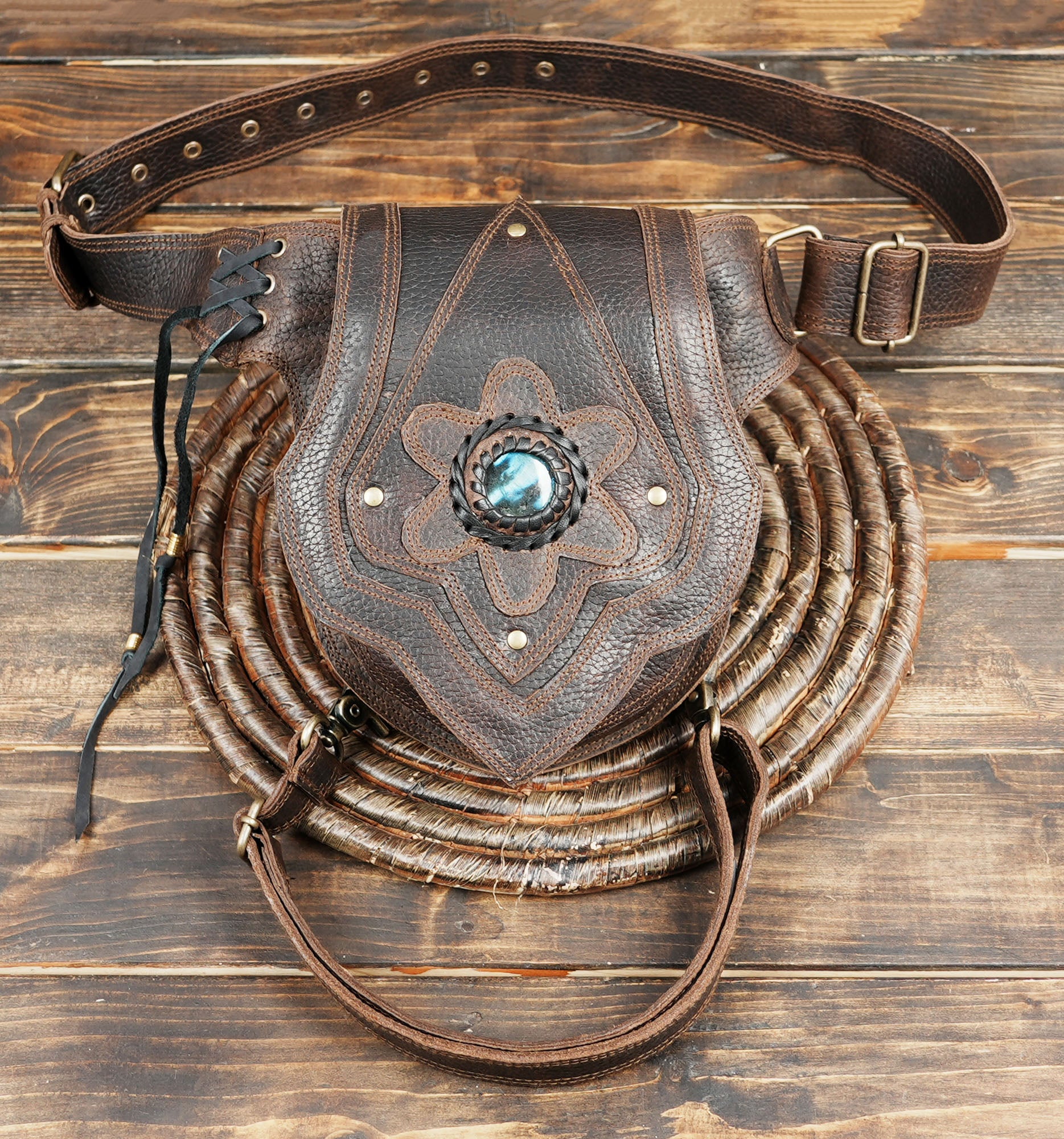 Close-up of brown leather hip pouch showing detailed stitching and gemstone