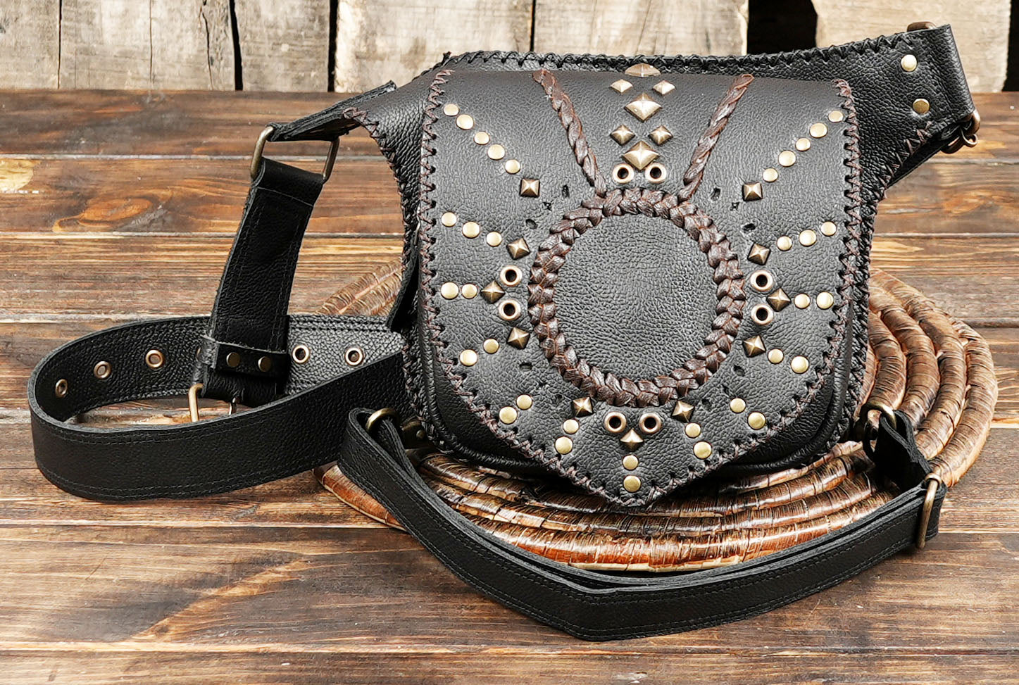 Model wearing handcrafted black leather leg holster bag on black pants.