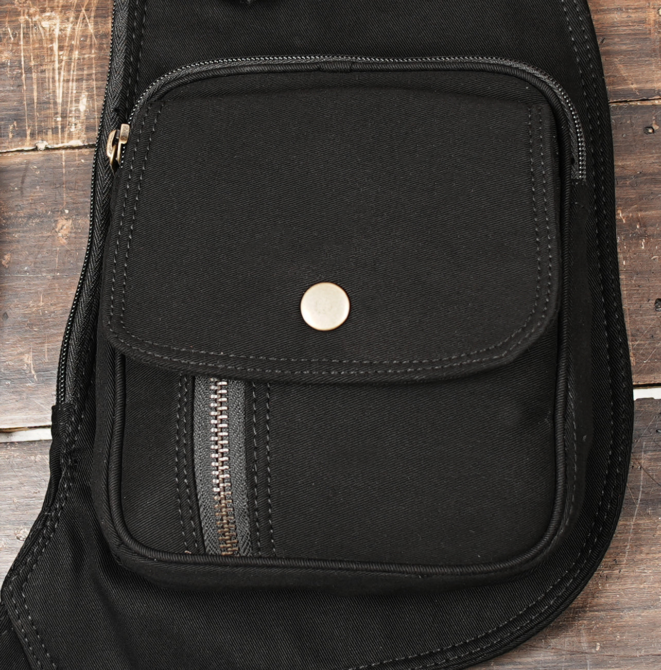 Close-up of black cotton holster bag showing front pocket and metal button