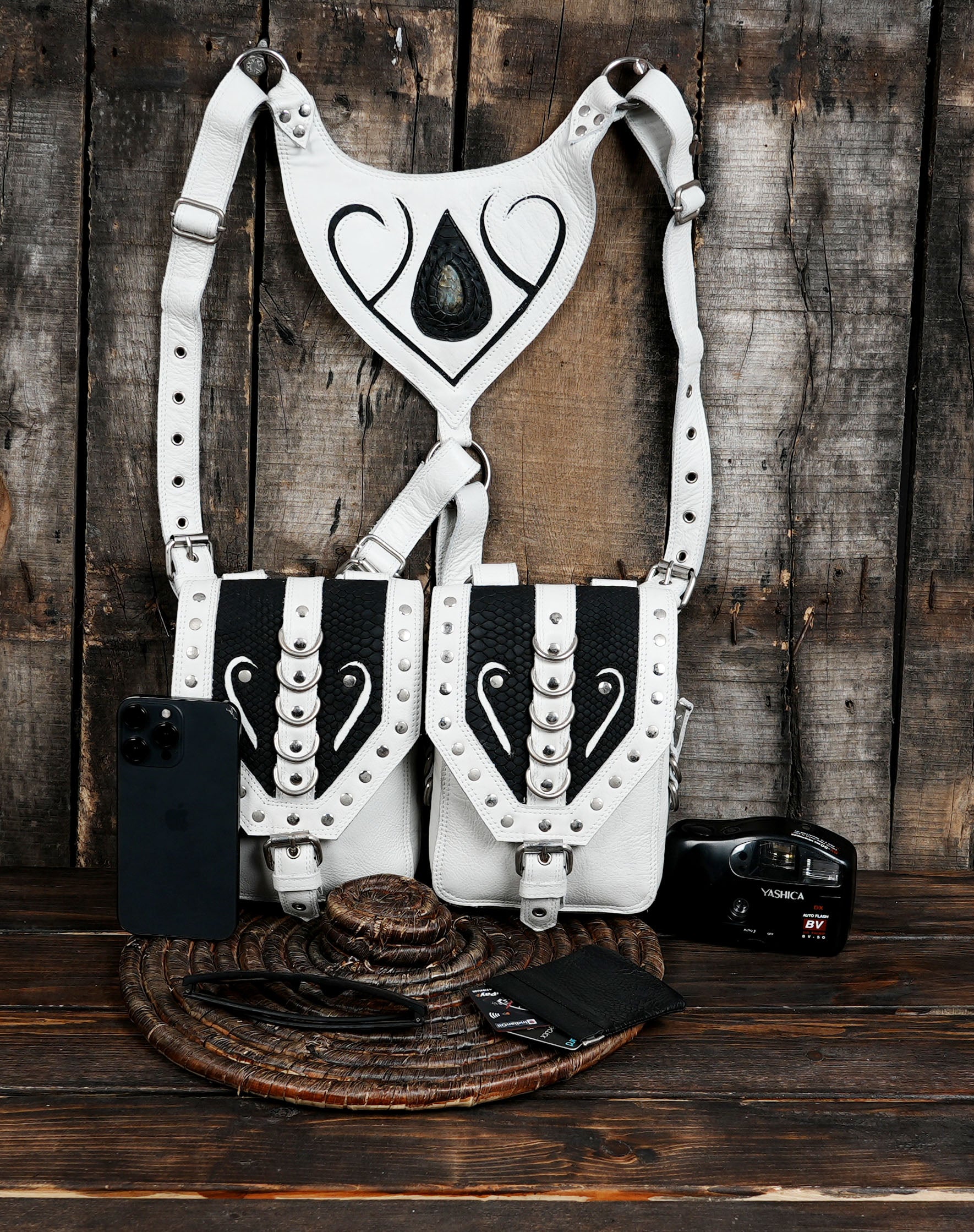 Made from premium genuine leather, it features striking white and black color contrast, detailed with rivets, buckles, and bold artistic stitching.