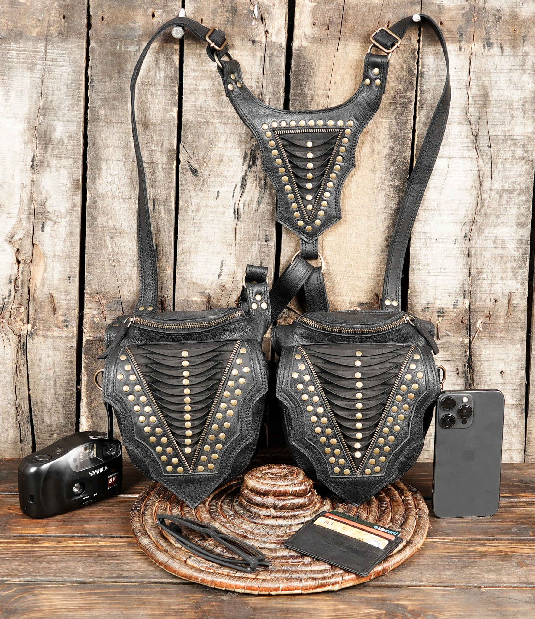 “Modern black leather holster harness with brass studs and adjustable buckles”