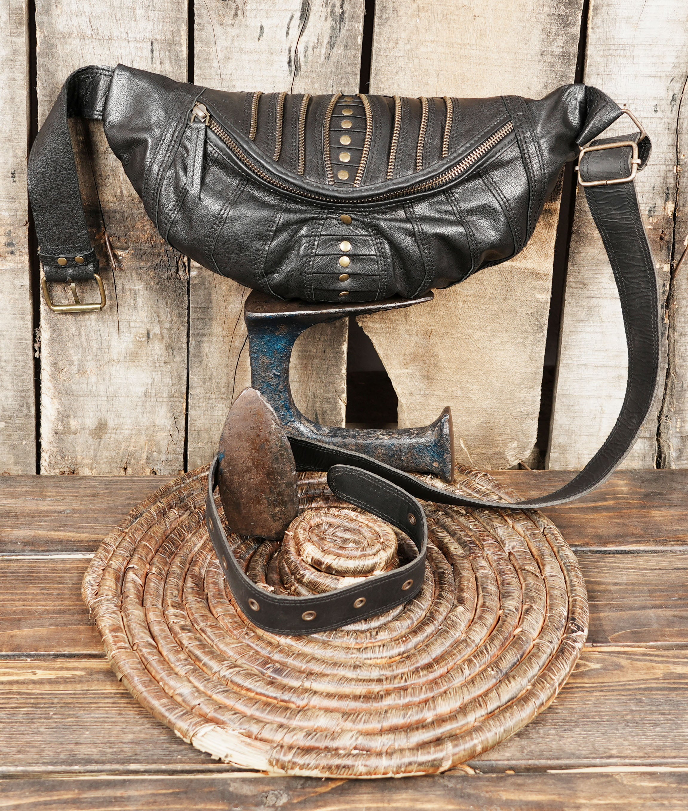 Black festival leather belt bag with rustic stitching and bold front design.