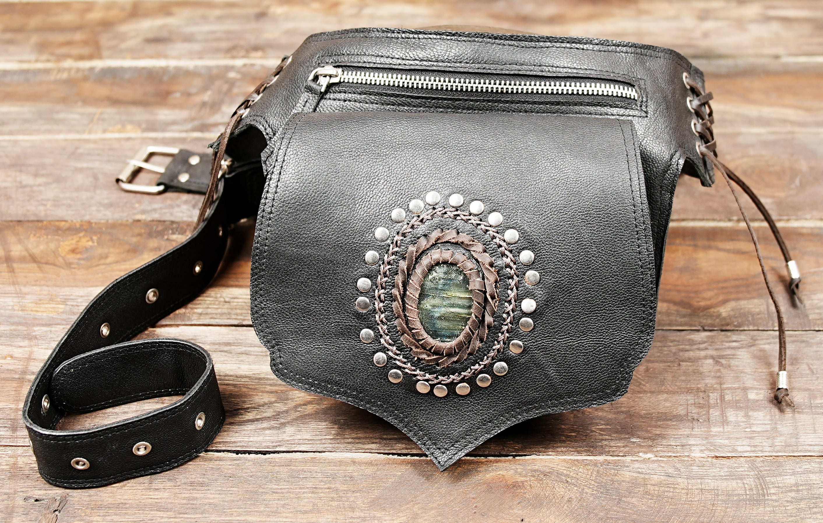 Bohemian leather waist pouch with gemstone decoration and braided leatherwork.