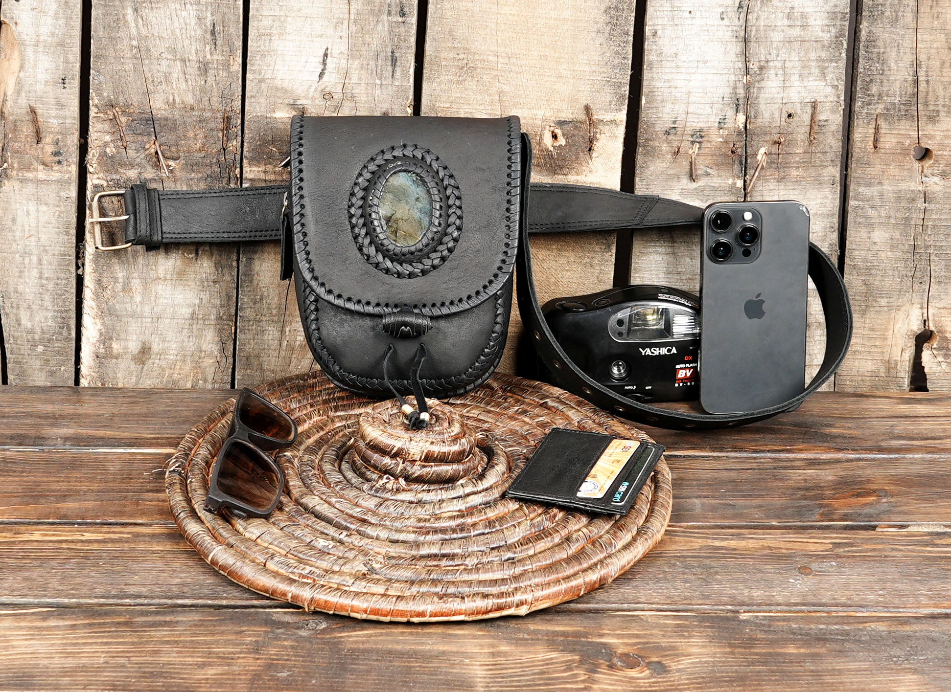 Black handmade leather fanny pack with stone detail on rustic background