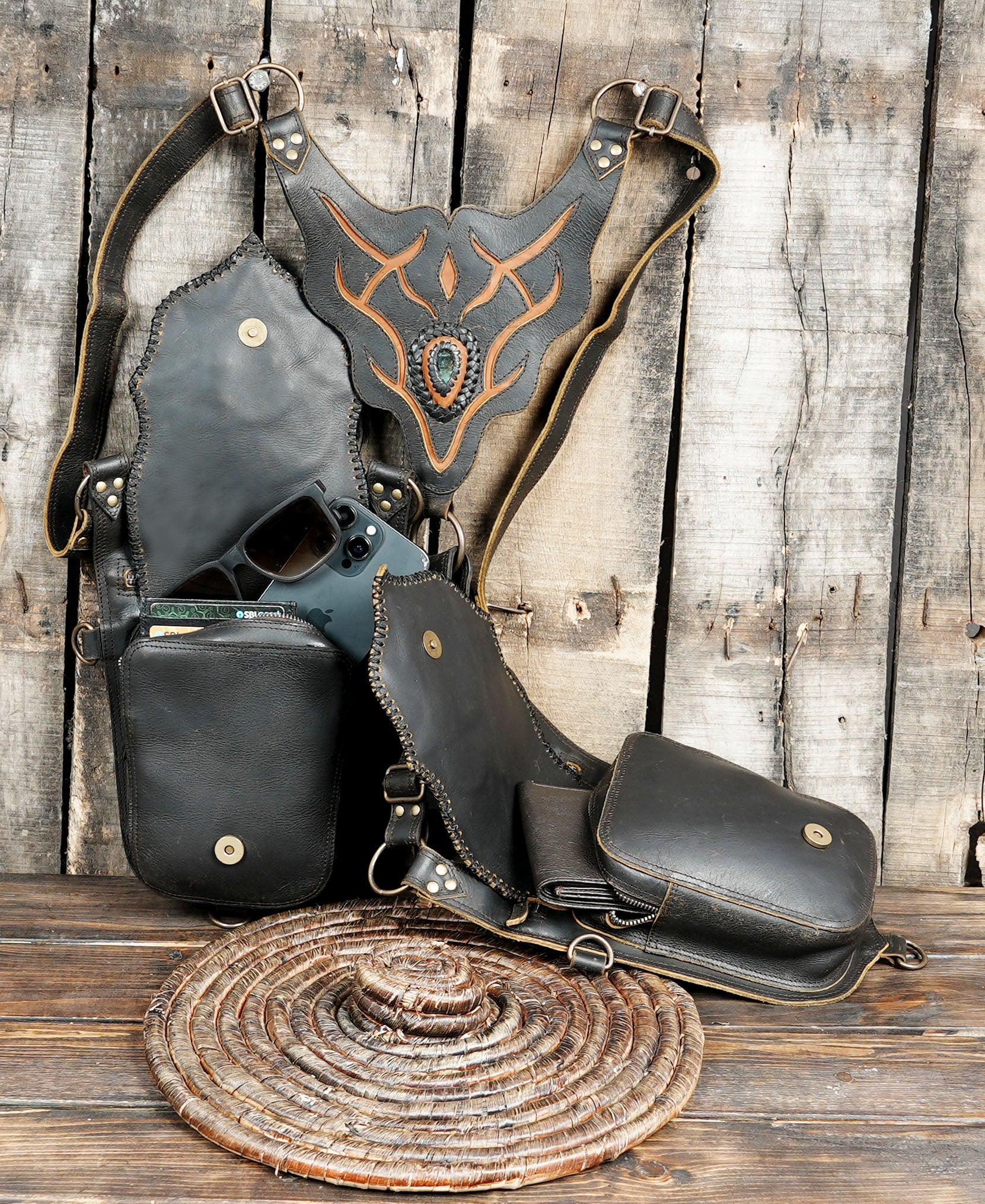 Black leather holster with decorative elements on a wooden surface
