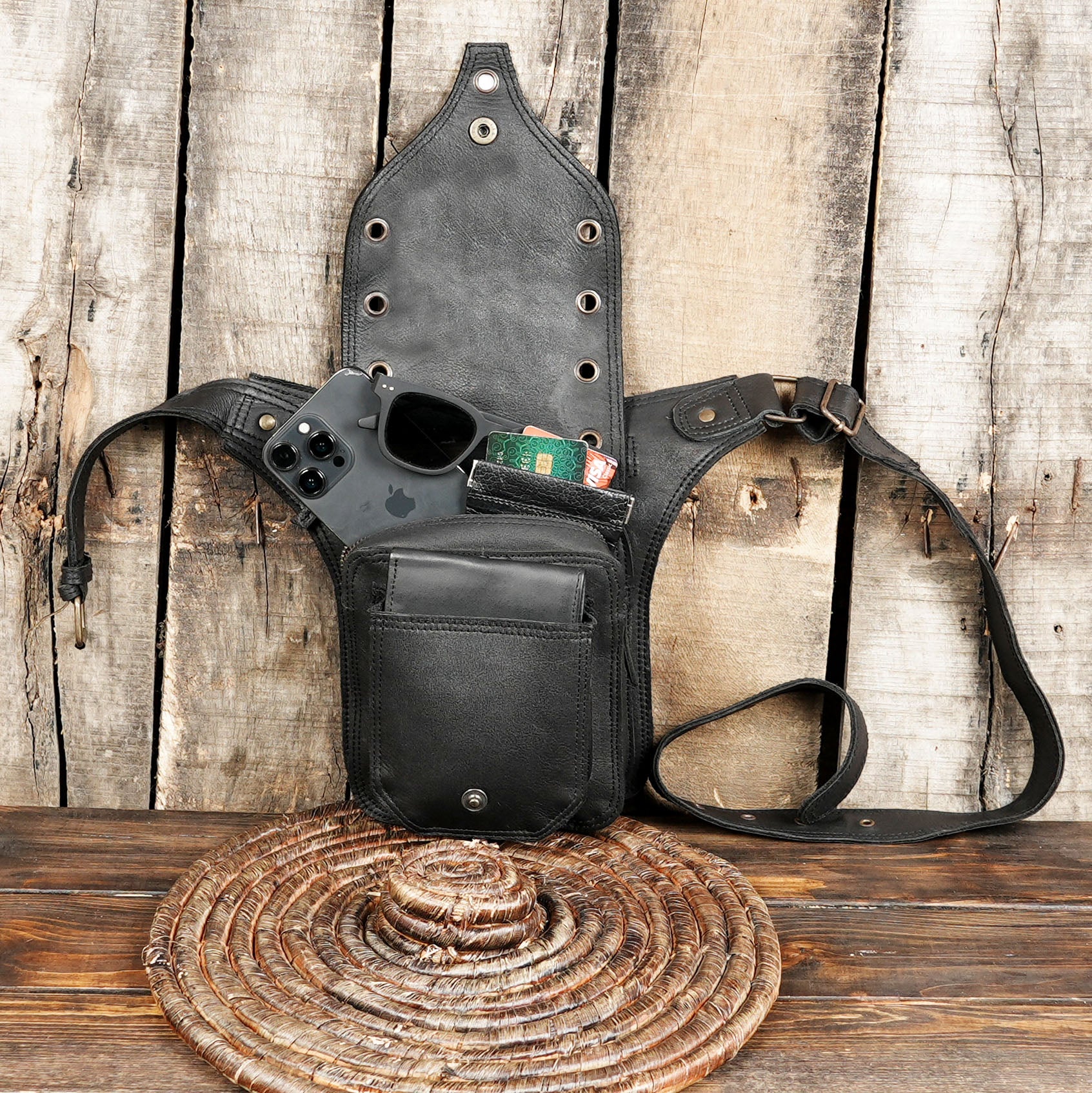 Adjustable black leather hip bag with edgy festival style