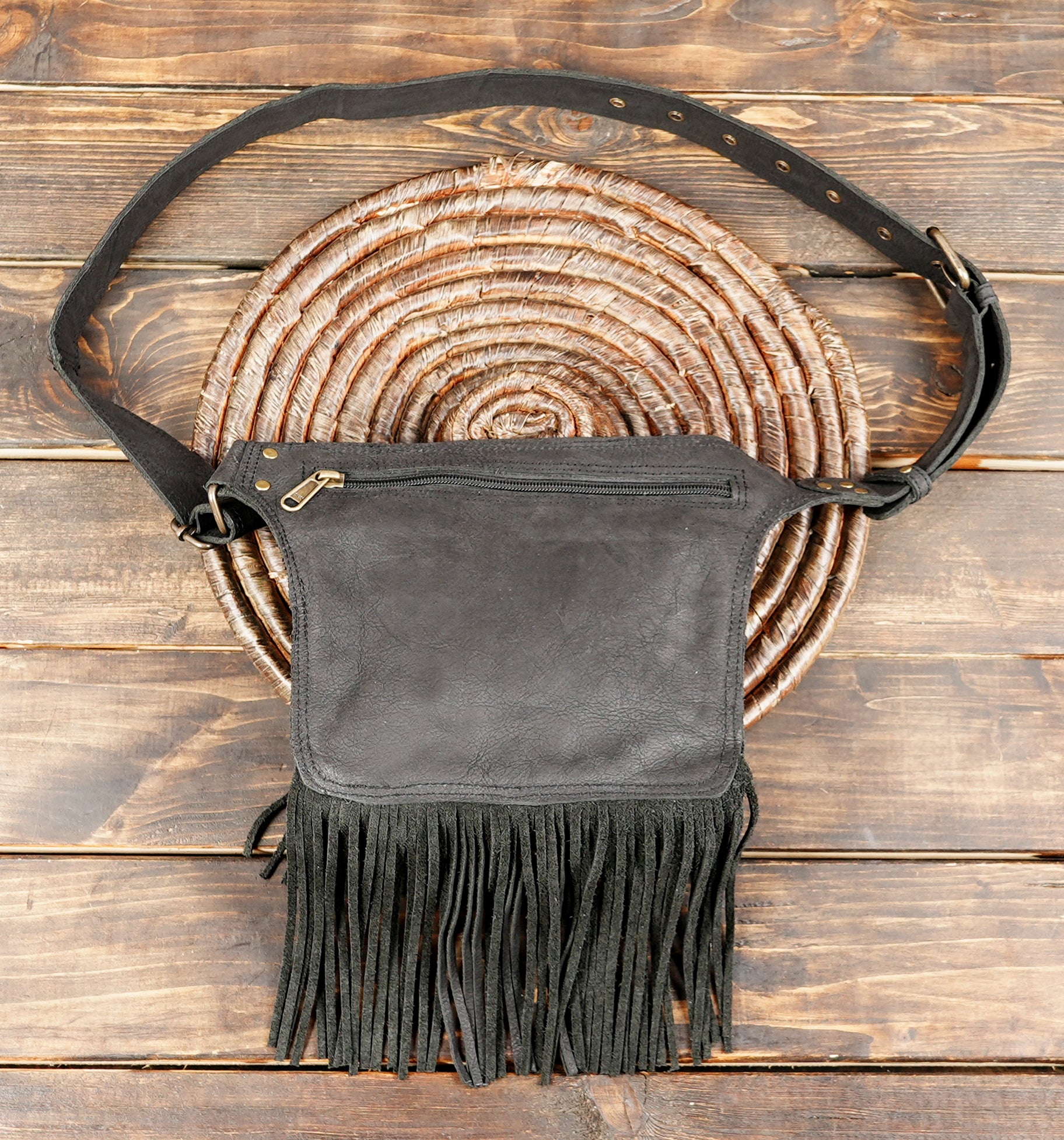 Western-inspired leather waist bag with long fringe and rustic detailing
