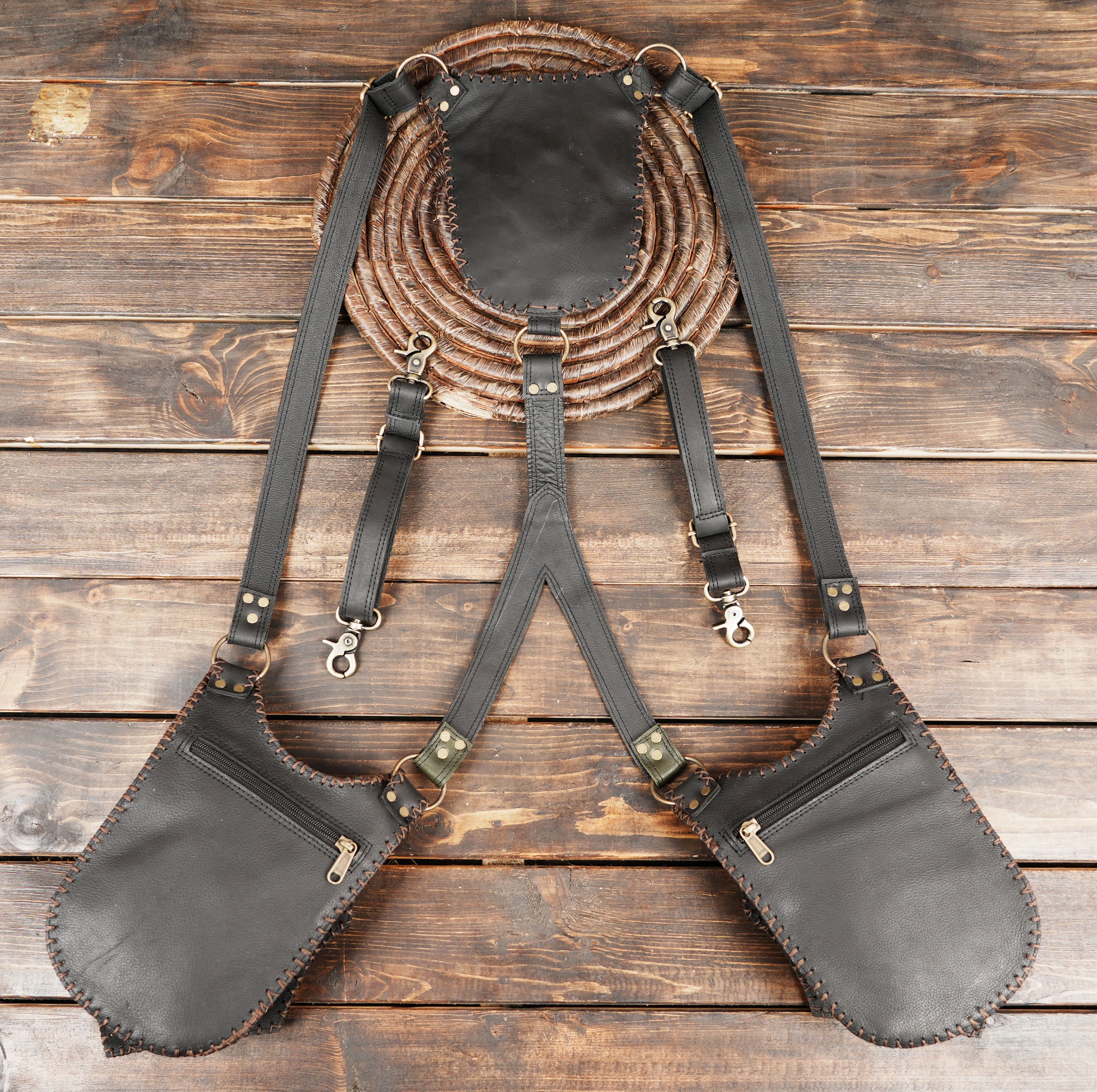 Dual pocket leather holster belt with handcrafted detailing and metal buckles.