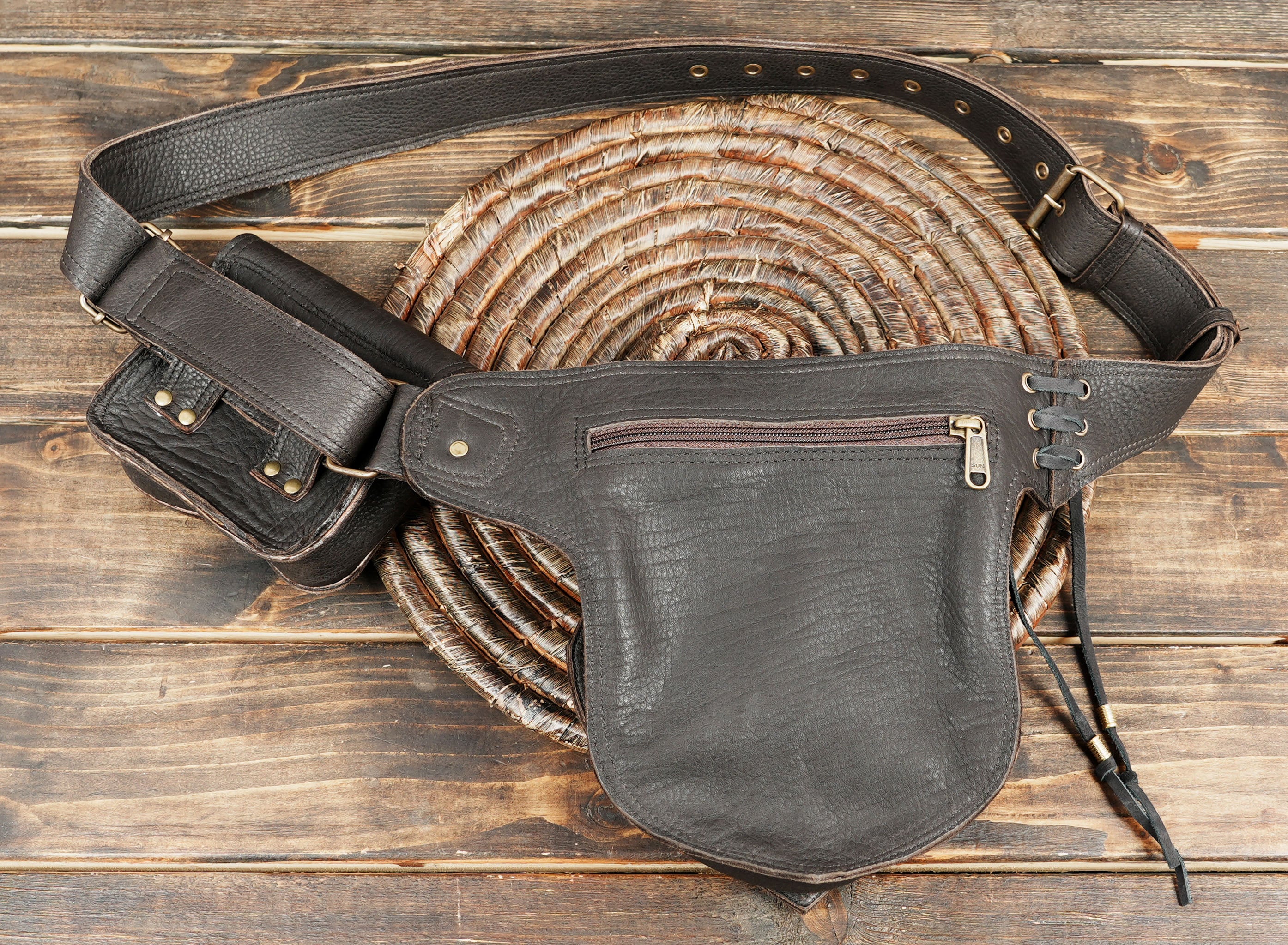open leather utility belt bag displaying interior space for wallet and sunglasses
