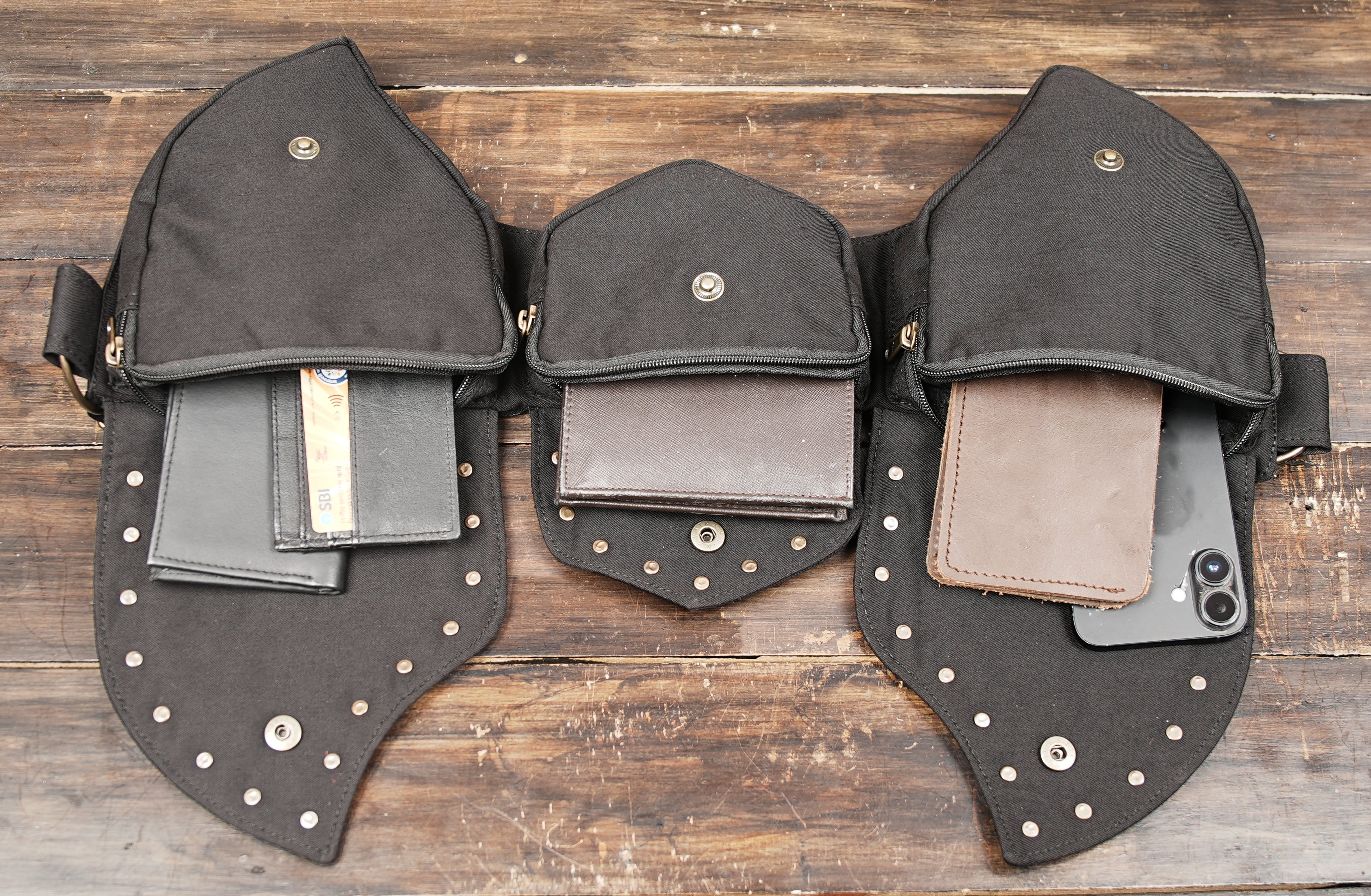 Black steampunk utility belt bag on wooden background