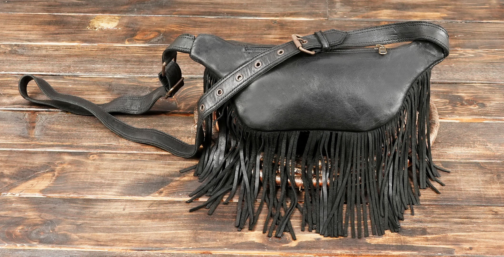 Stylish black leather fanny pack with fringe and front zipper pocket