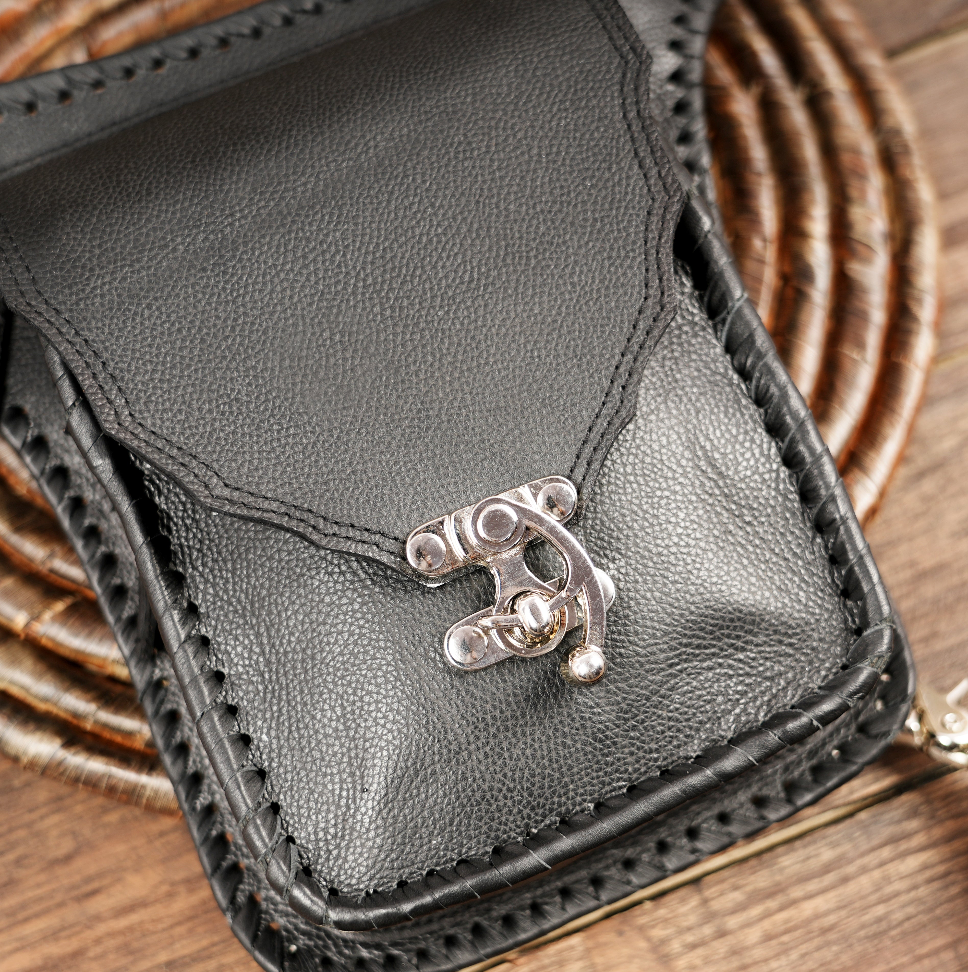 Close-up of handcrafted black leather hip bag with detailed stitching