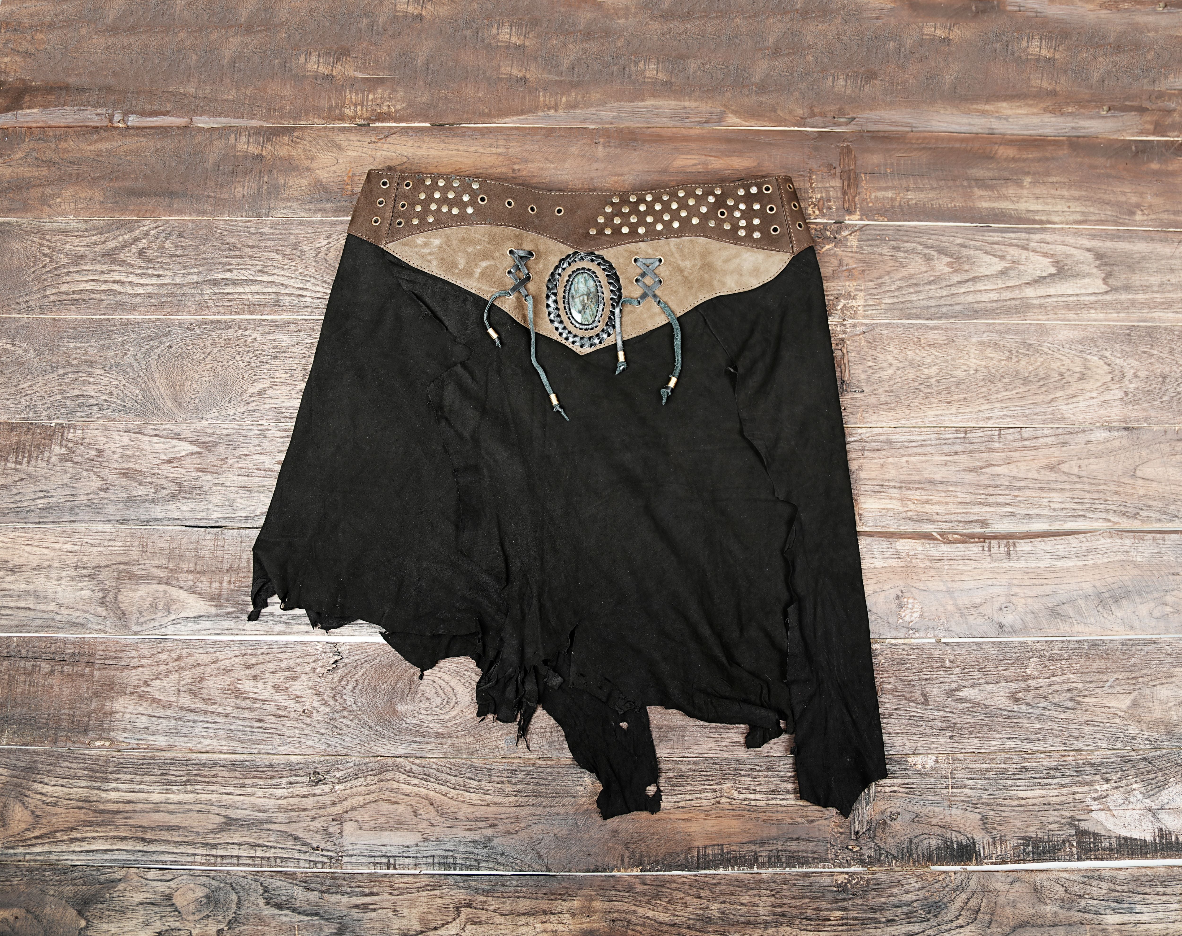 “Handmade black suede leather skirt with brown waistband, gemstone centerpiece, and boho festival design.”