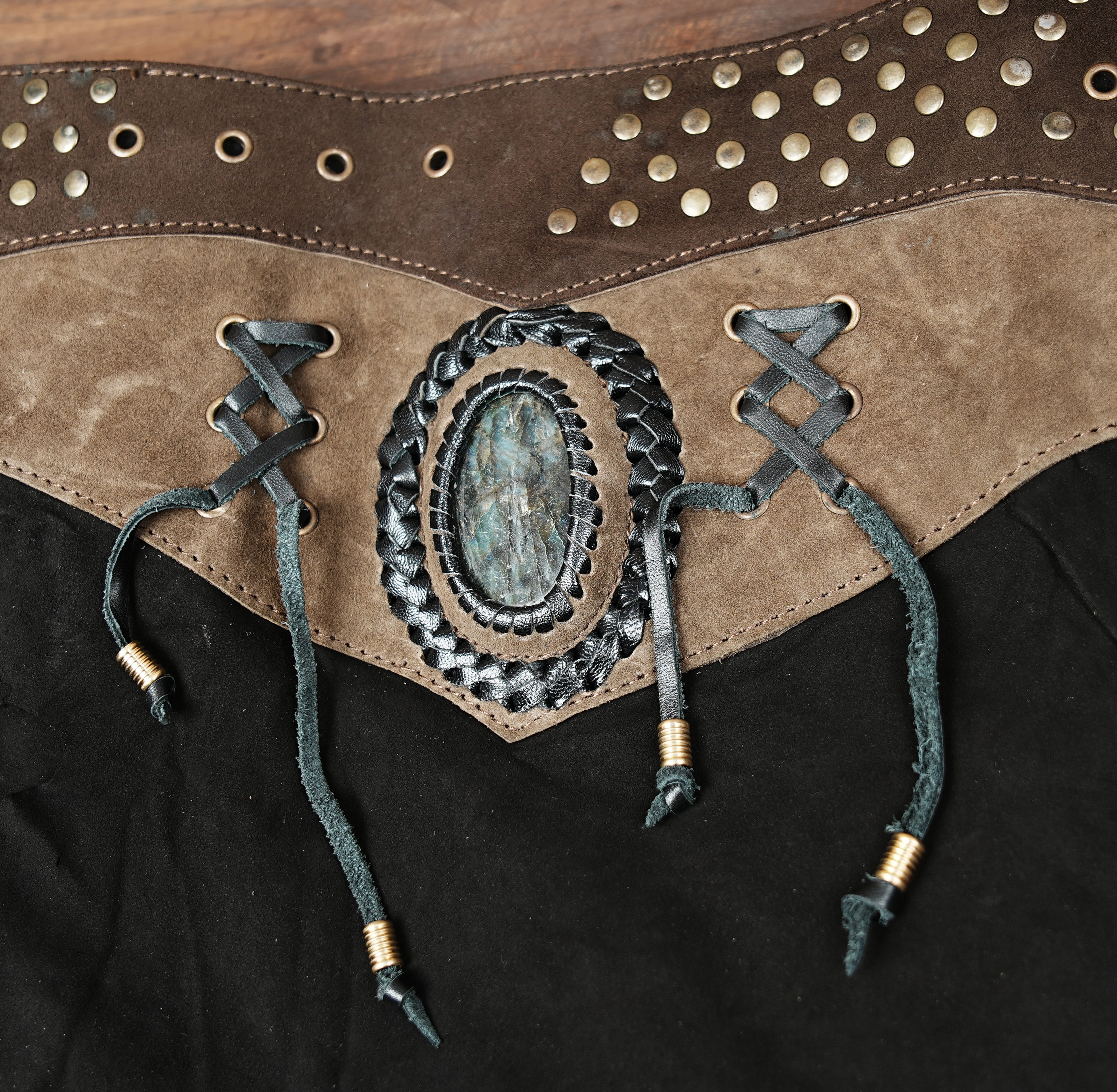 “Black and brown leather skirt with gemstone accent and rugged hem, handmade boho steampunk clothing.”