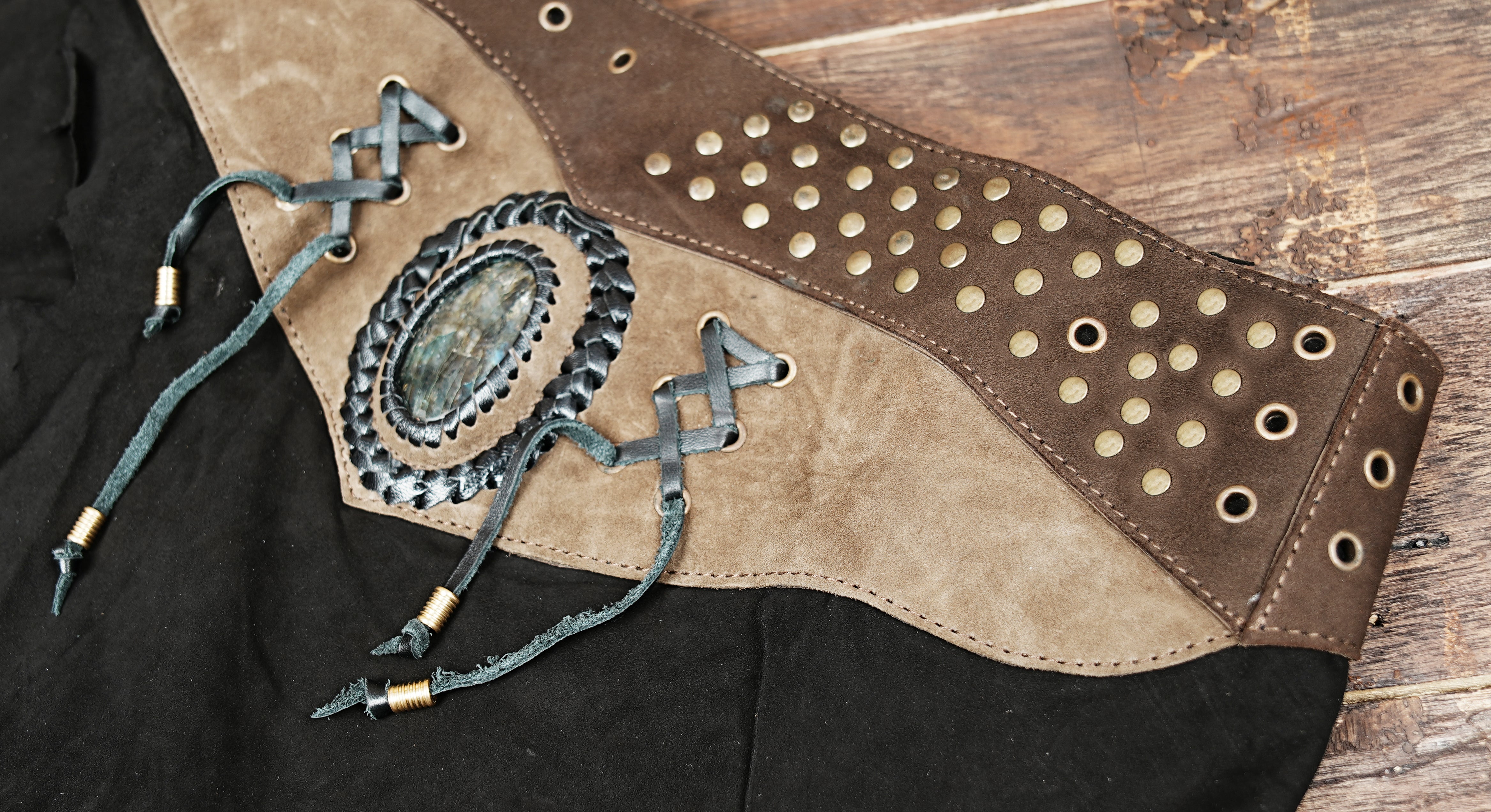 Black leather skirt with gemstone centerpiece, rustic waistband and gothic cosplay style.