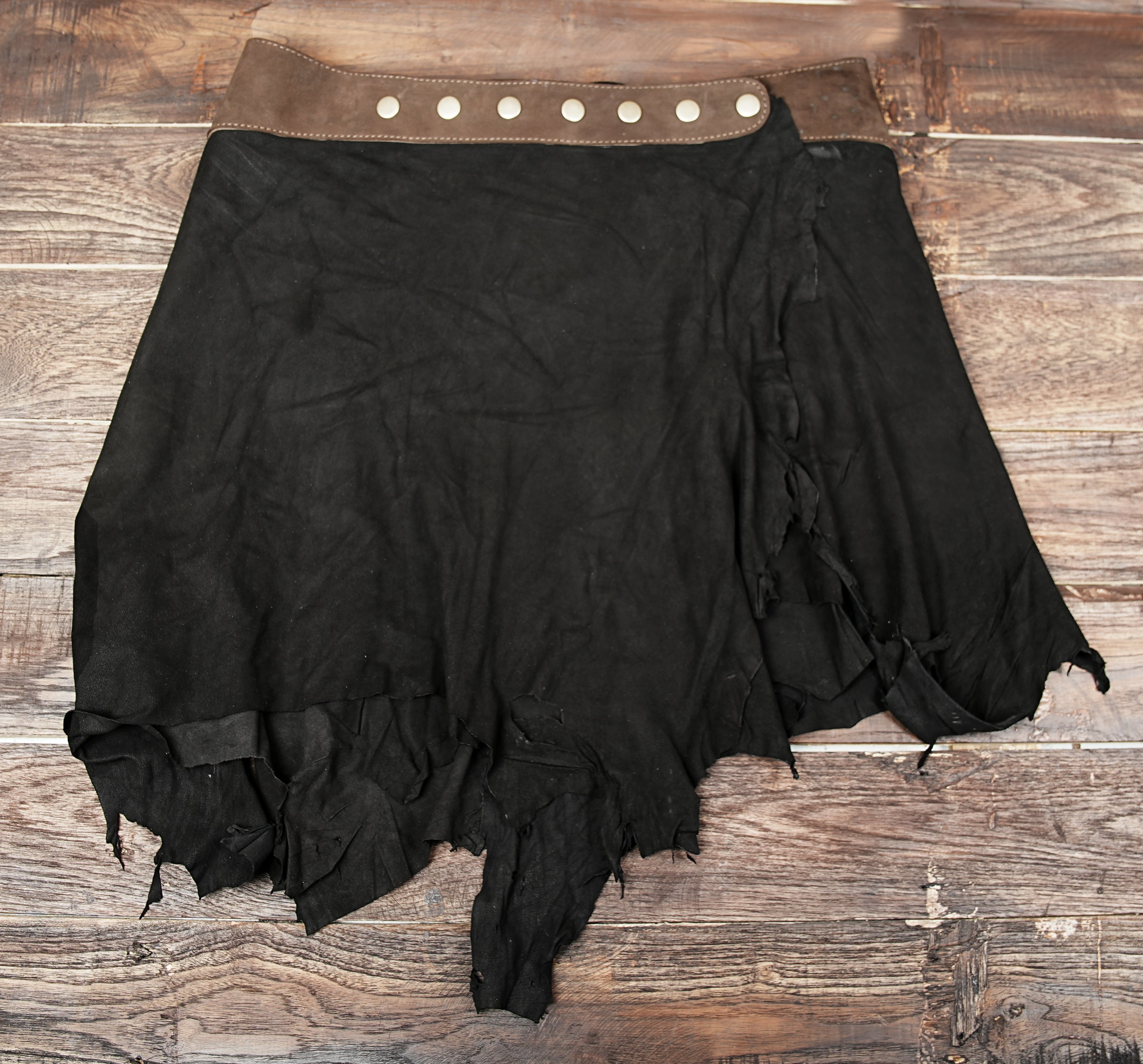 “Tribal steampunk suede skirt with gemstone centerpiece, handmade boho gothic fashion.”