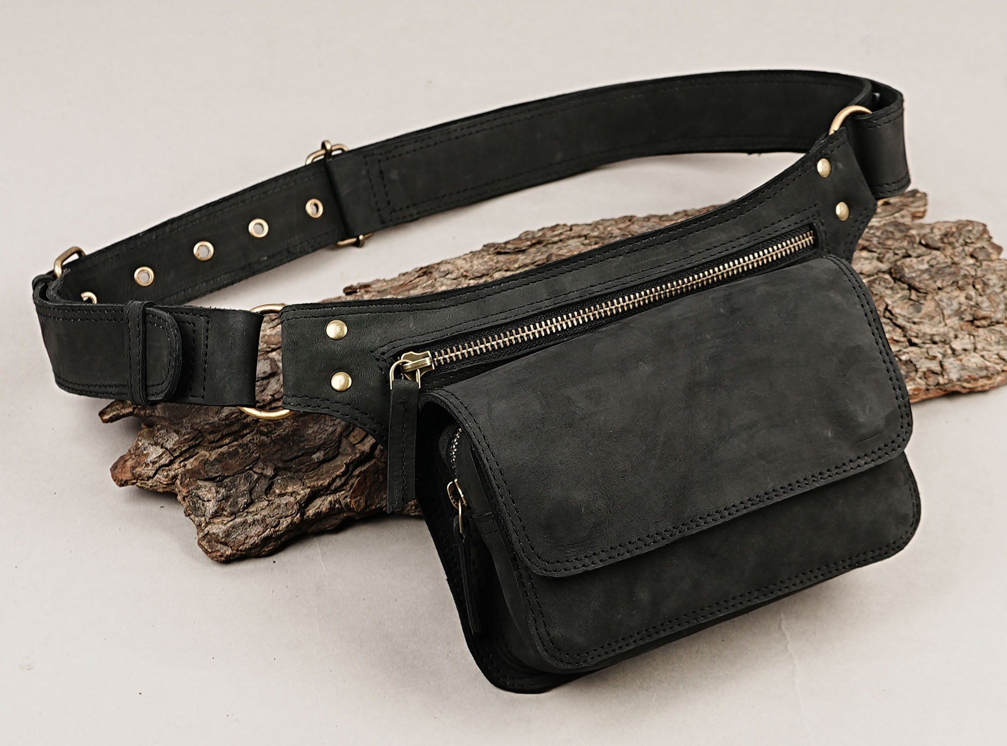 Inside of black leather waist bag with wallet and phone