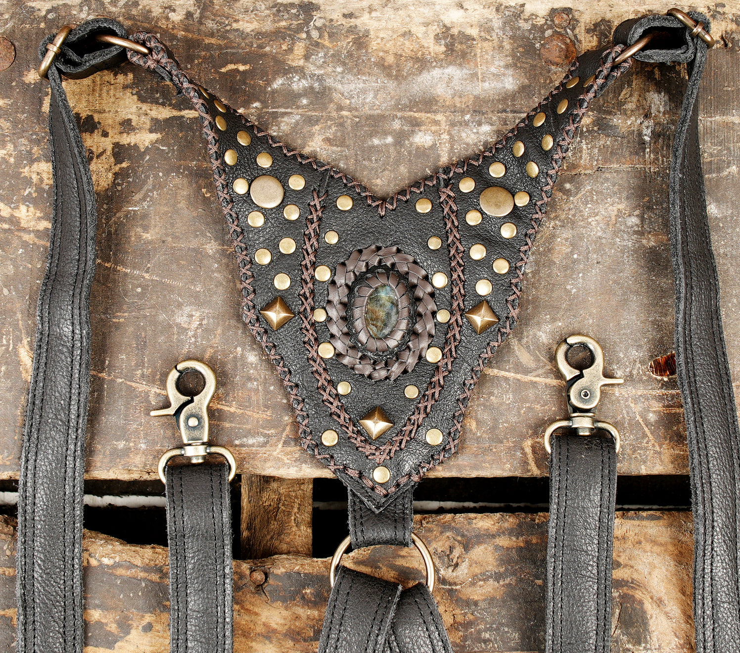 “Steampunk black leather holster harness with brass rivets and carved trim”