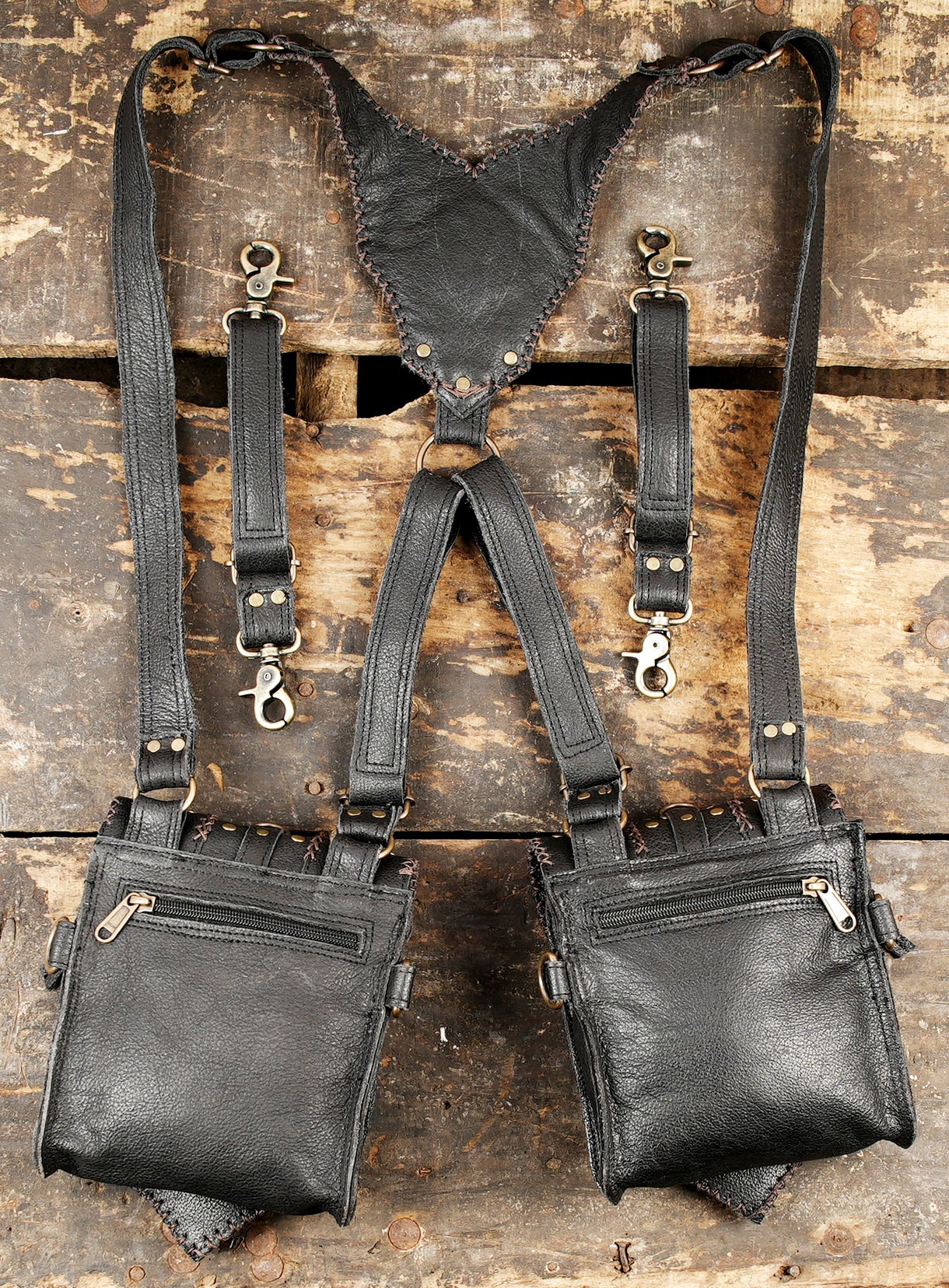 “Handmade chest holster in black leather with rivets and braided panels”