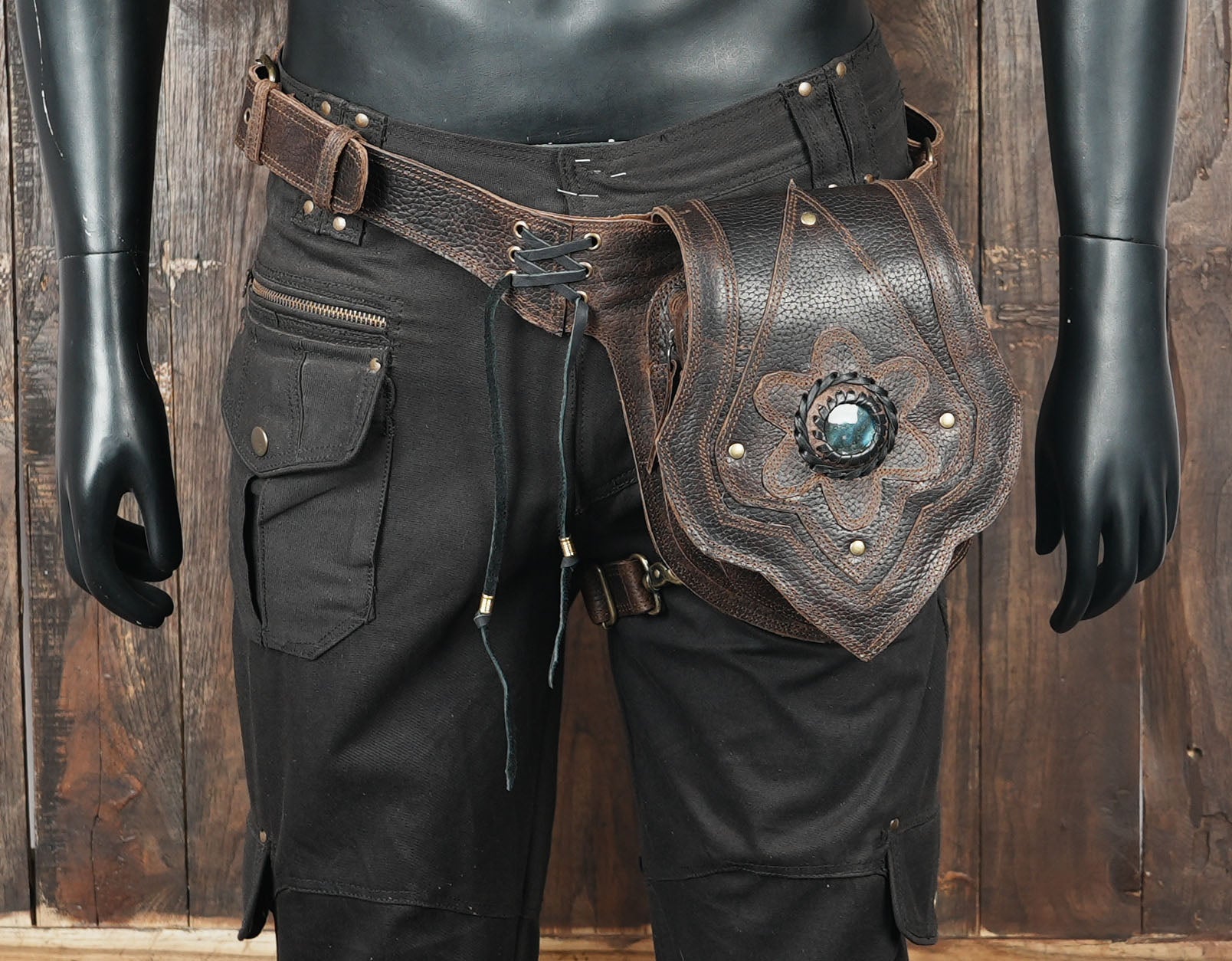 Unique artisan leather hip pouch with detailed stitching and gemstone art