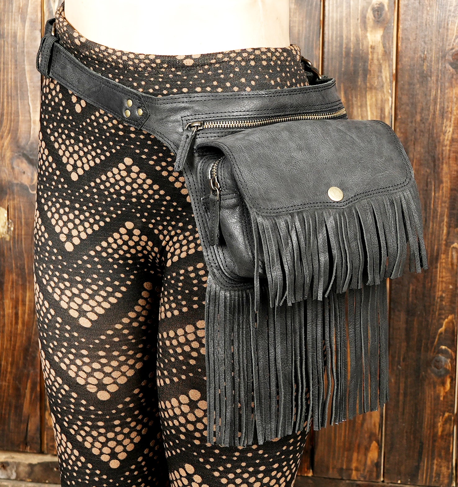 Artisan-made bohemian leather belt bag with layered fringe and secure buckle.