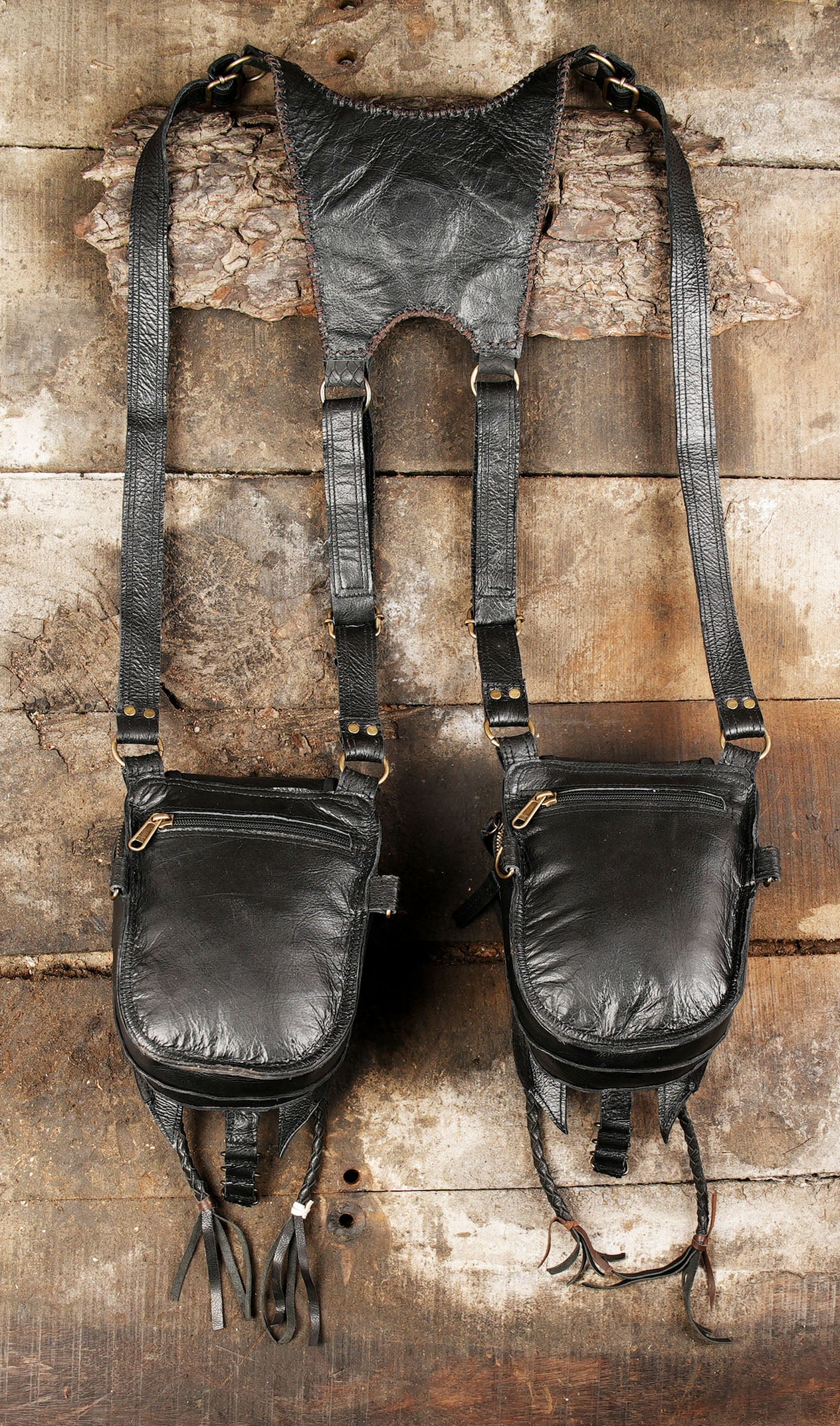 “Dual pouch artisan leather holster with carved details and braided tassels”